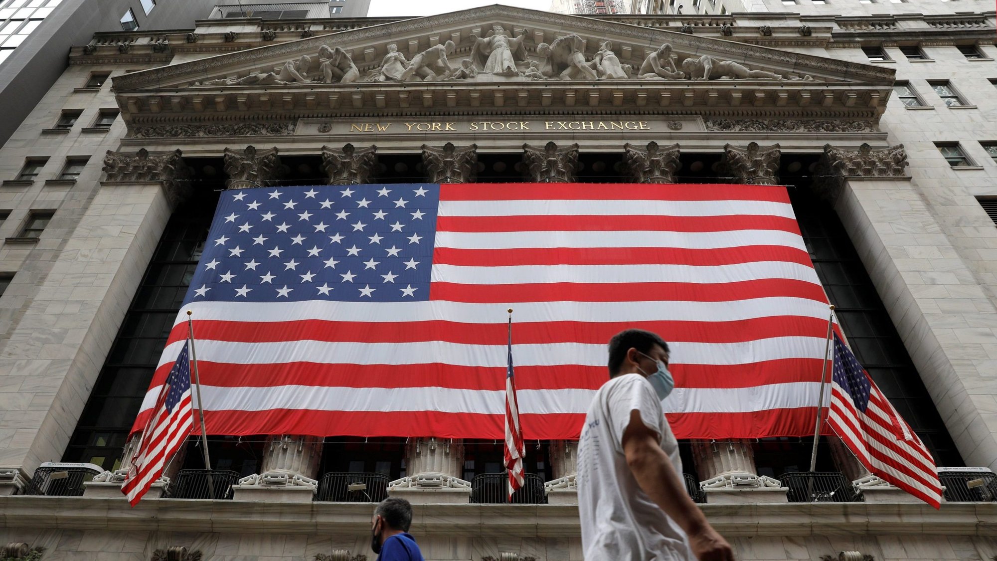 People in New York City walk by American flags Aug. 9, 2021. On Aug. 11, the Senate passed a $3.5 trillion spending package that includes immigration reform provisions, including creating a path to citizenship for 10 million people in the U.S. illegally. (CNS photo/Andrew Kelly, Reuters)