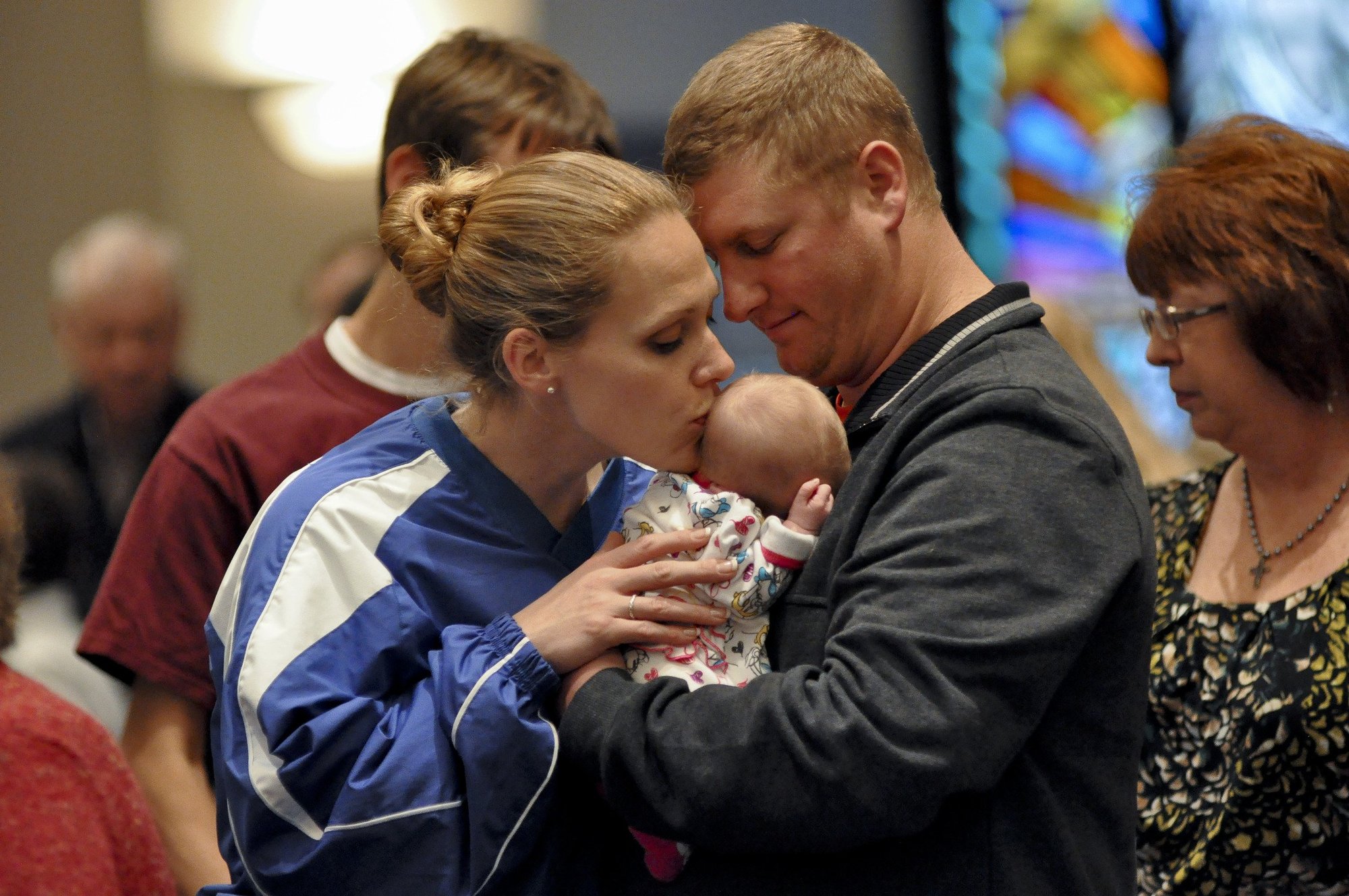 Greg Armbruster of Greenwood, Indiana holds his newborn daughter, Catherine Michelle, as mother Laura gives her a kiss. (CNS/Mary Ann Garber, The Criterion)