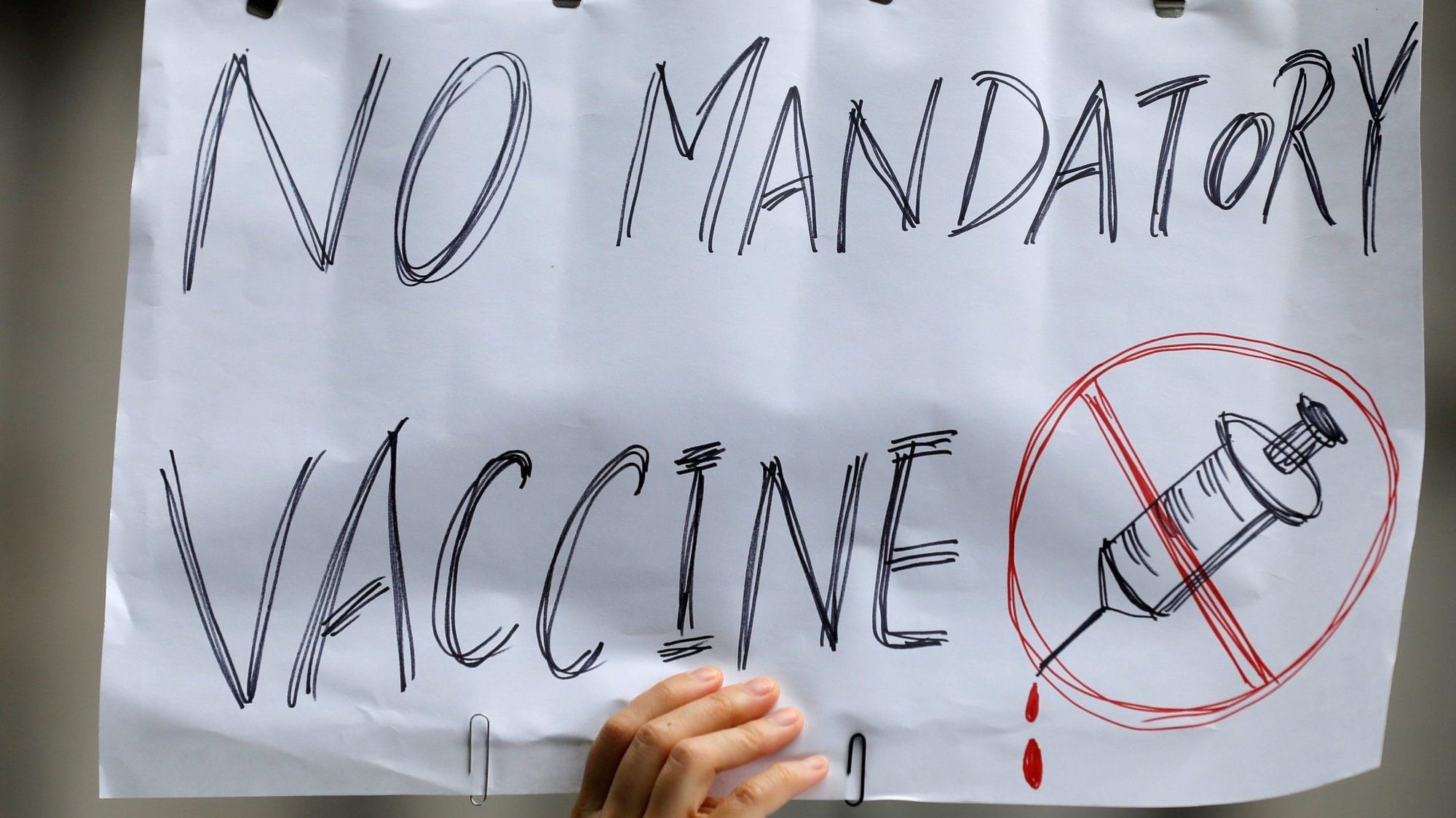 A person in New York City holds up a sign Aug. 9, 2021, during during a protest against mandated COVID-19 vaccines and vaccine passports. (CNS photo/Andrew Kelly, Reuters)