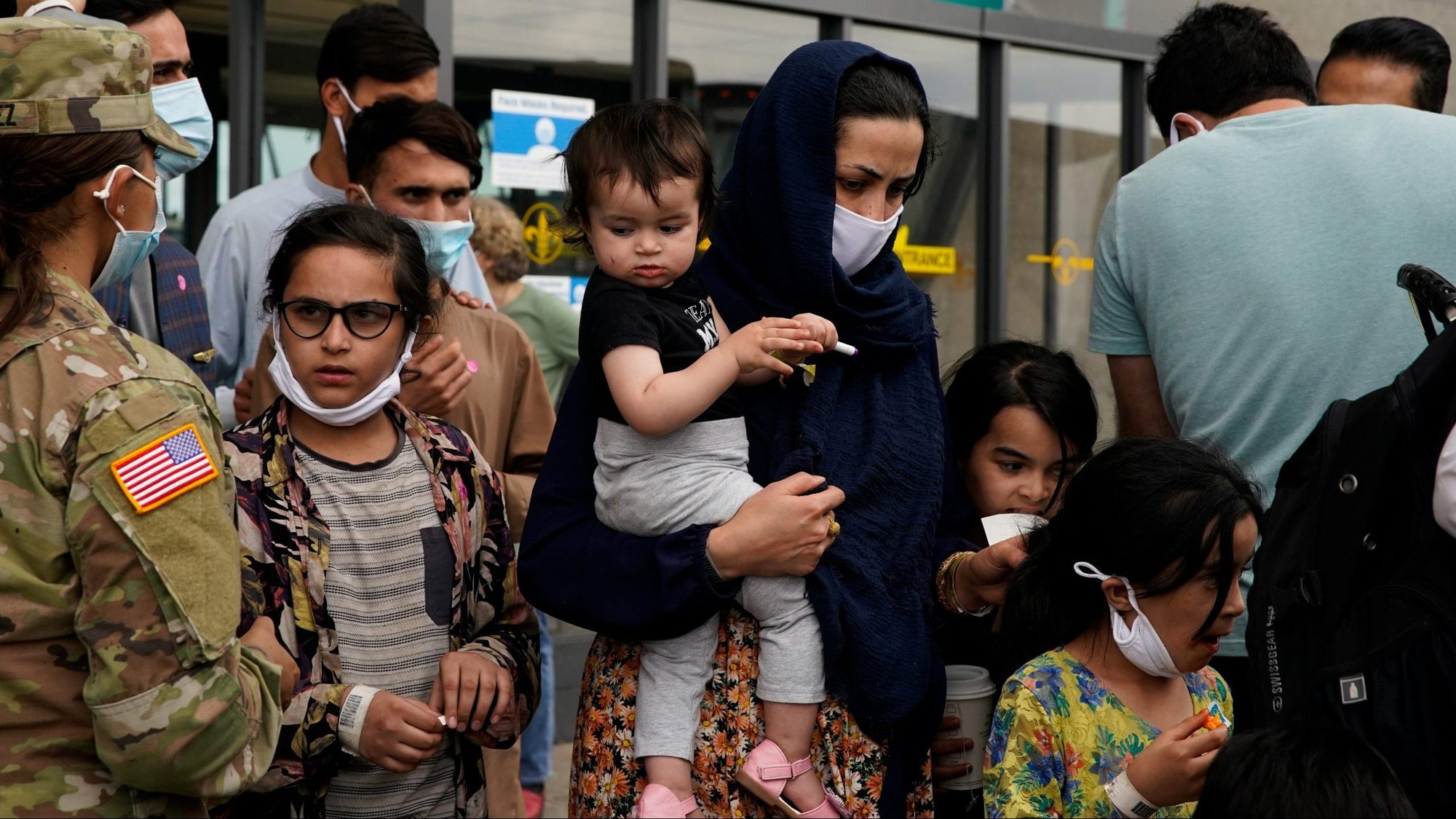 Afghan refugees in Dulles, Va., board a bus taking them to a processing center Aug. 29, 2021, upon arrival at Dulles International Airport. (CNS photo/Elizabeth Frantz, Reuters)