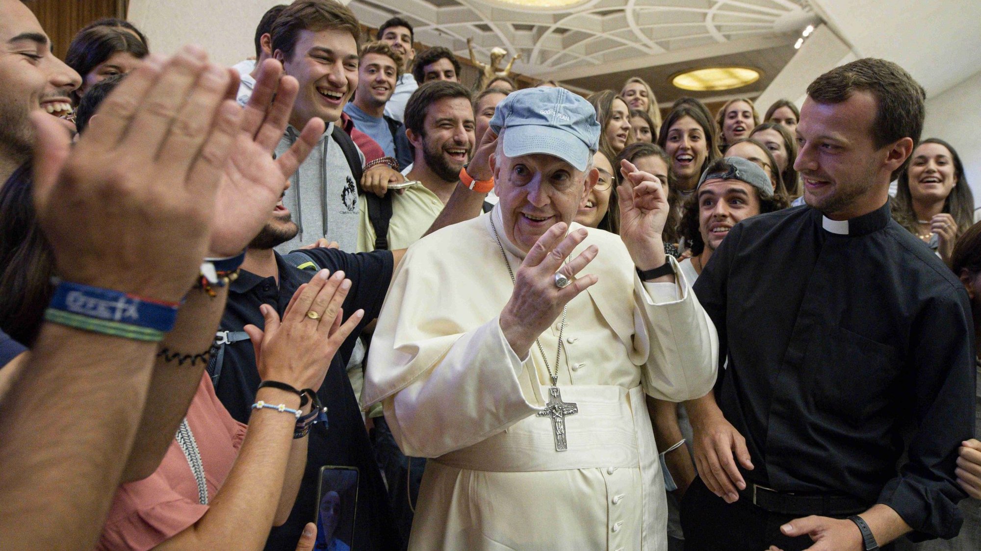 Pope Francis tries on a blue hat during his general audience in the Paul VI hall at the Vatican Sept. 1, 2021. (CNS photo/Vatican Media)