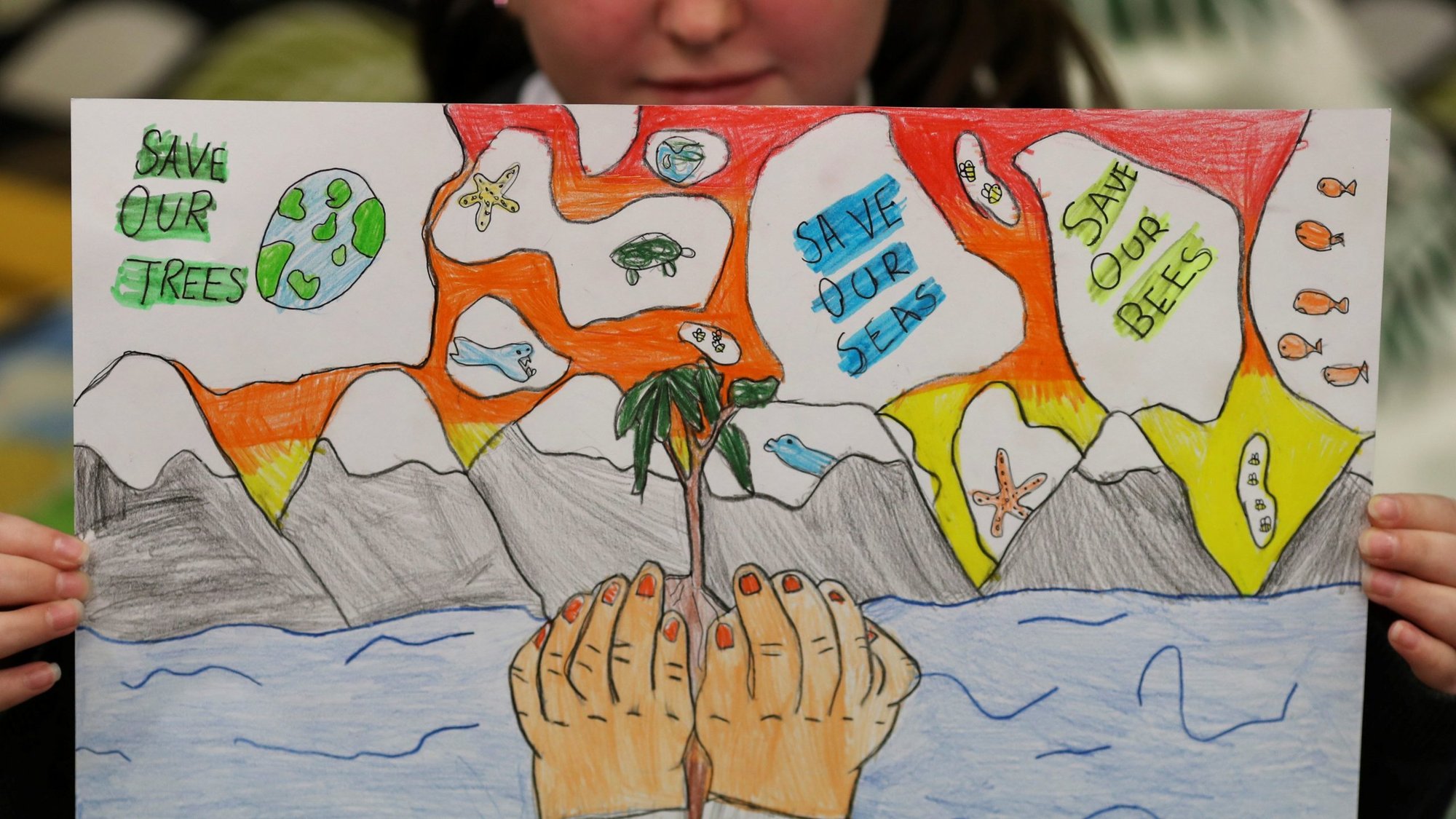 A student holds a poster at St. Conval's Primary School while learning about climate change ahead of the U.N. Climate Change Conference, COP26, in Glasgow, Scotland, Oct. 19, 2021. (CNS photo/Russell Cheyne, Reuters)