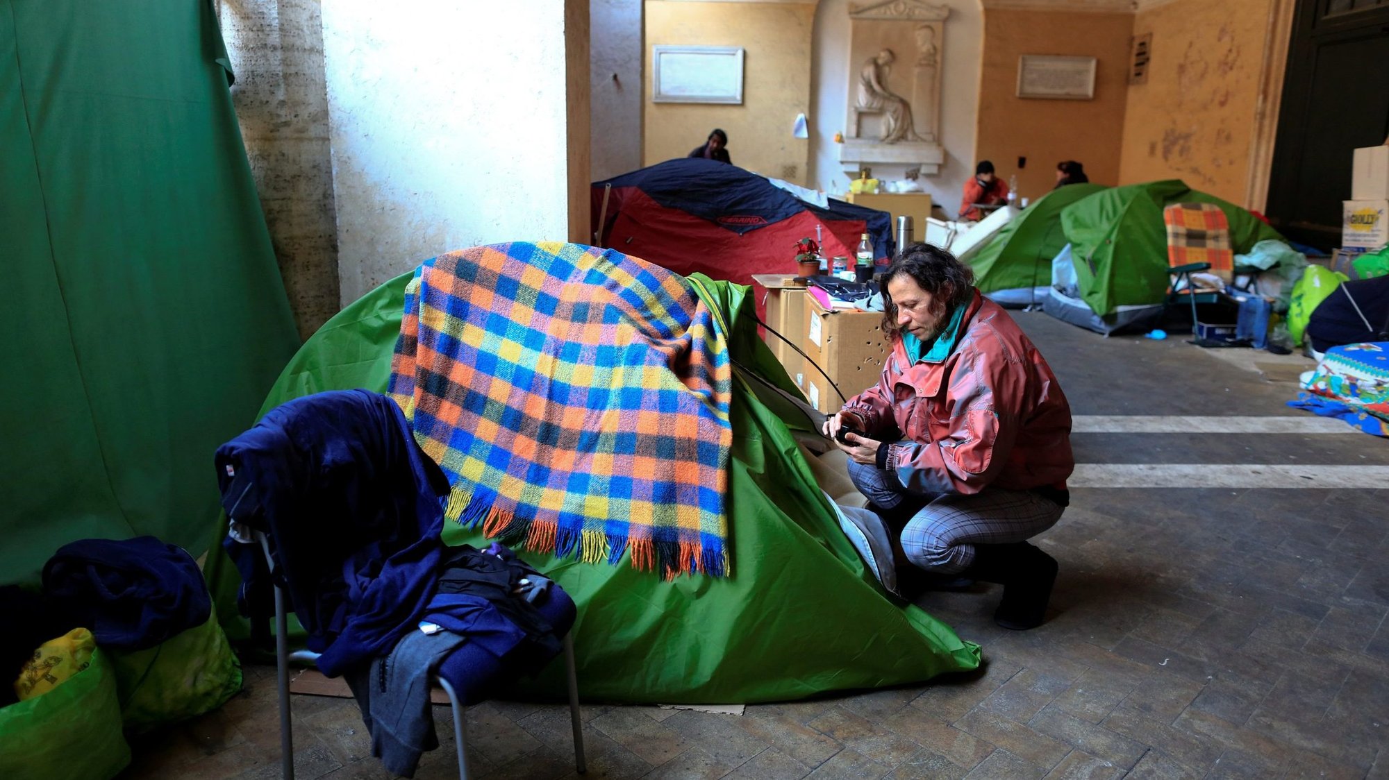 Angela Grossi is seen next to her tent in the portico of the Santi Apostoli basilica where she lives after being evicted from an unused building along with other families, in this photo taken in Rome Jan. 29, 2018. Pope Francis called on Catholics to see the suffering of people around them, stop to help and be open to continual conversion. (CNS photo/Tony Gentile, Reuters)