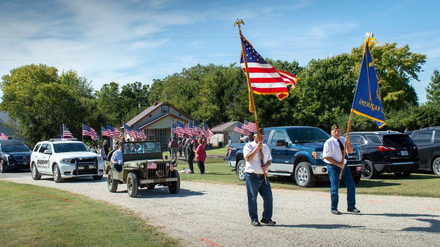 Veterans in Pilsen, Kan., walk in front of a motorcade for Father Emil J. Kapaun near near St. John Nepomucene Church Sept. 25, 2021. A candidate for sainthood, Father Kapaun died May 23, 1951, while ministering to prisoners of war during the Korean War. (Christopher M. Riggs/Catholic Advance, via CNS)
