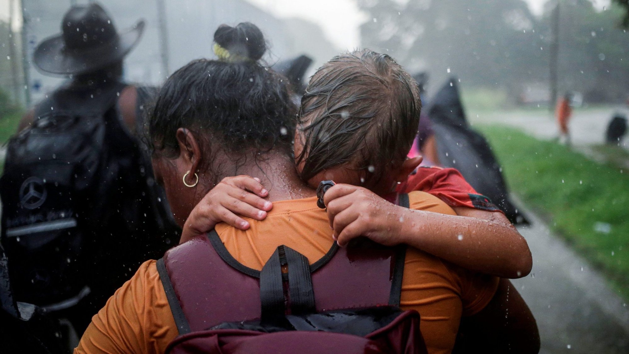 A migrant woman in Acacoyagua, Mexico, carries her boy in the rain Oct. 29, 2021, as they walk in a caravan heading to Mexico City. (CNS photo/Daniel Becerril, Reuters)