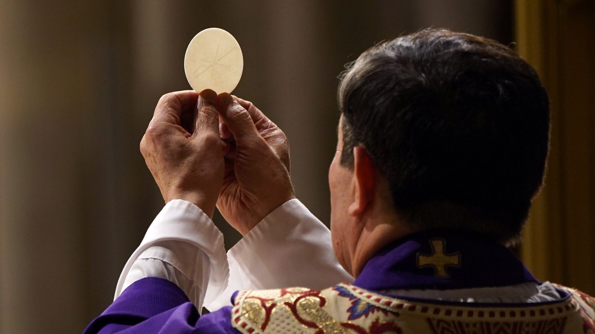 A priest elevates the host during a Mass at St. Patrick's Cathedral in New York City April 18, 2020. (CNS photo/Gregory A. Shemitz)