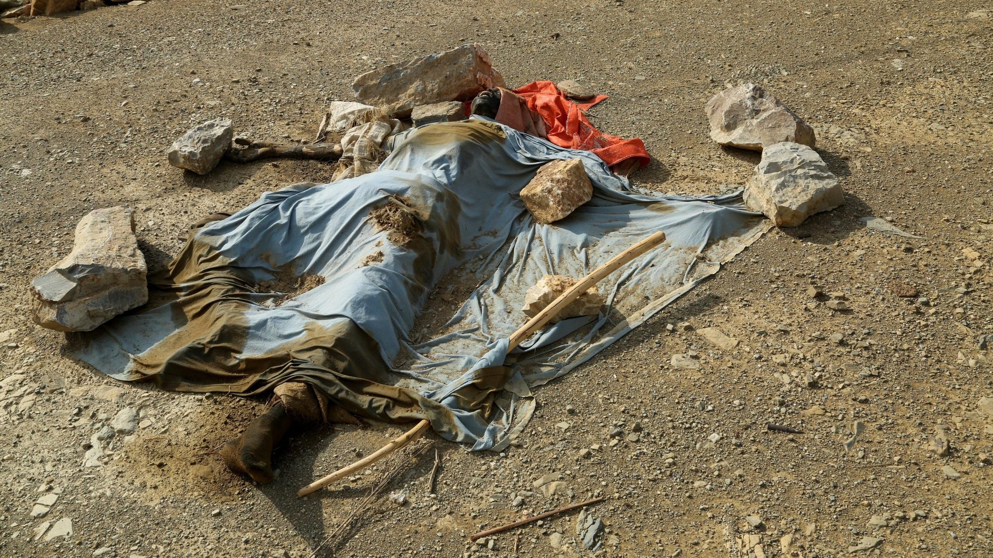 The body of a soldier from the Ethiopian military lies covered on the main road of the village of Sheweate Hugum in Ethiopia's Tigray region July 10, 2021. The U.N. High Commission for Human Rights and Ethiopian Human Rights Commission said both sides in the wat had committed abuses that amounted to war crimes (CNS photo/Giulia Paravicini, Reuters)