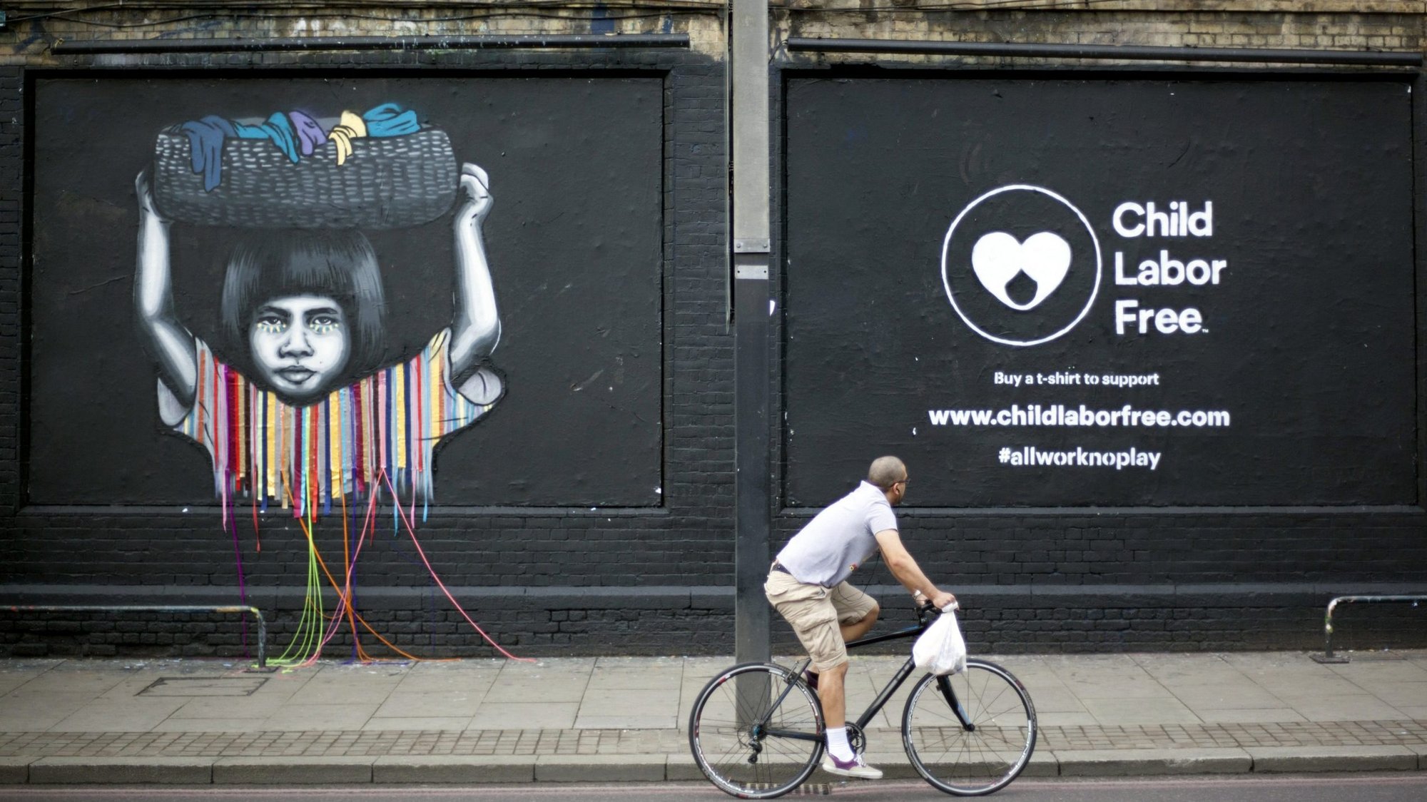 A cyclist passes a mural created by street artists depicting child labor in London June 8, 2016. Pope gave a talk to participants of an international conference on child labor in the Apostolic Palace at the Vatican Nov. 19, 2021. (CNS photo/Shanshan Chen, Reuters)