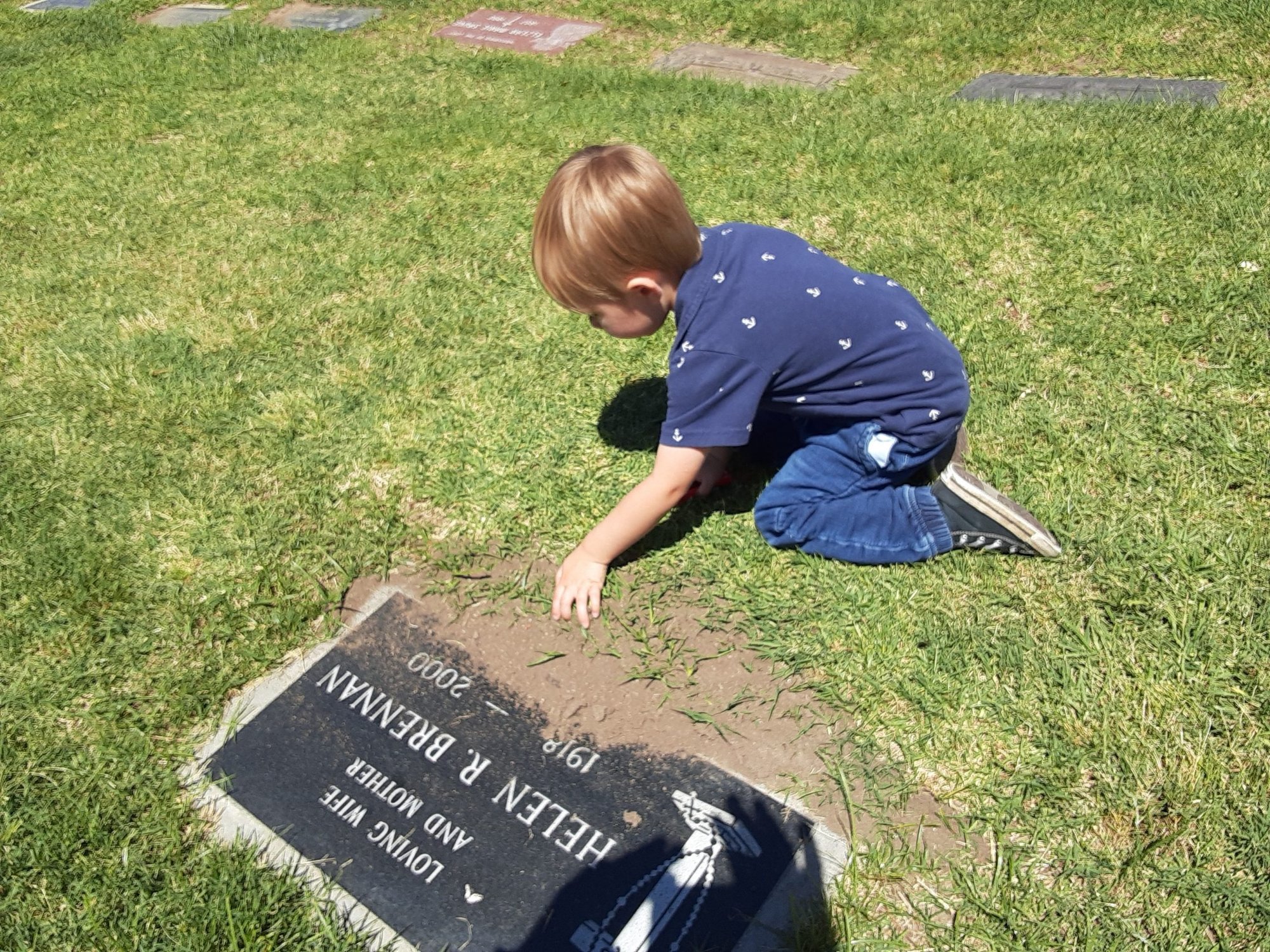 The author's grandson at the gravesite of his great-grandparents. (Robert Brennan)
