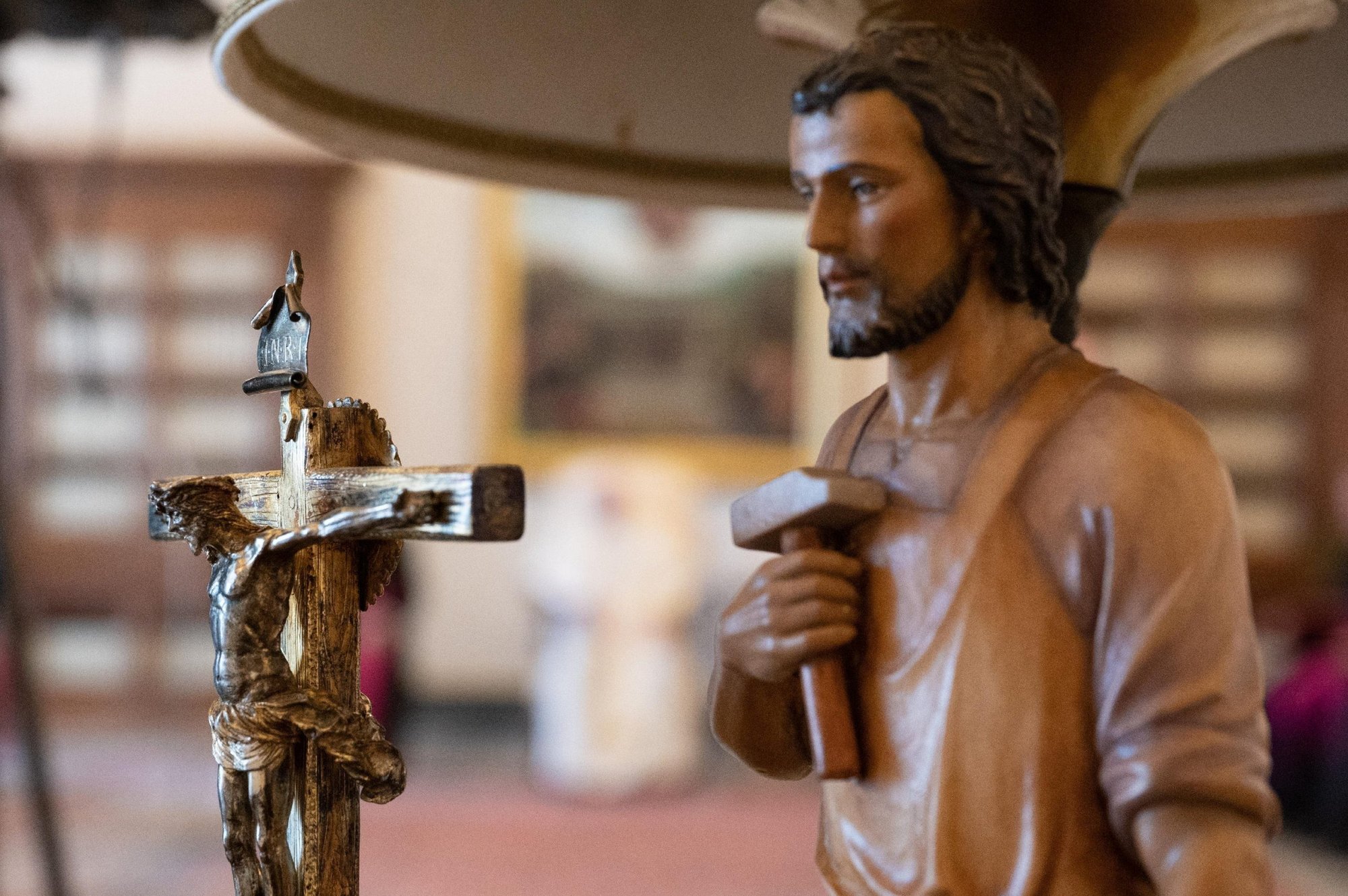 A crucifix and a statue of St. Joseph are seen in the Apostolic Library with Pope Francis in the background. The pope declared 2021 the Year of St. Joseph. (CNS photo/Vatican Media)