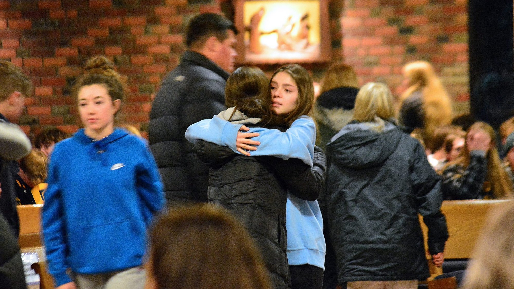 Oxford High School students comfort one another Nov. 30, 2021, following a Mass at St. Joseph Church in Lake Orion, Mich., hours after a mass shooting at the school left three students dead and eight other people wounded. Authorities said a 15-year-old Oxford sophomore was in custody after the shooting. (CNS photo/Michael Stechschulte, Detroit Catholic)