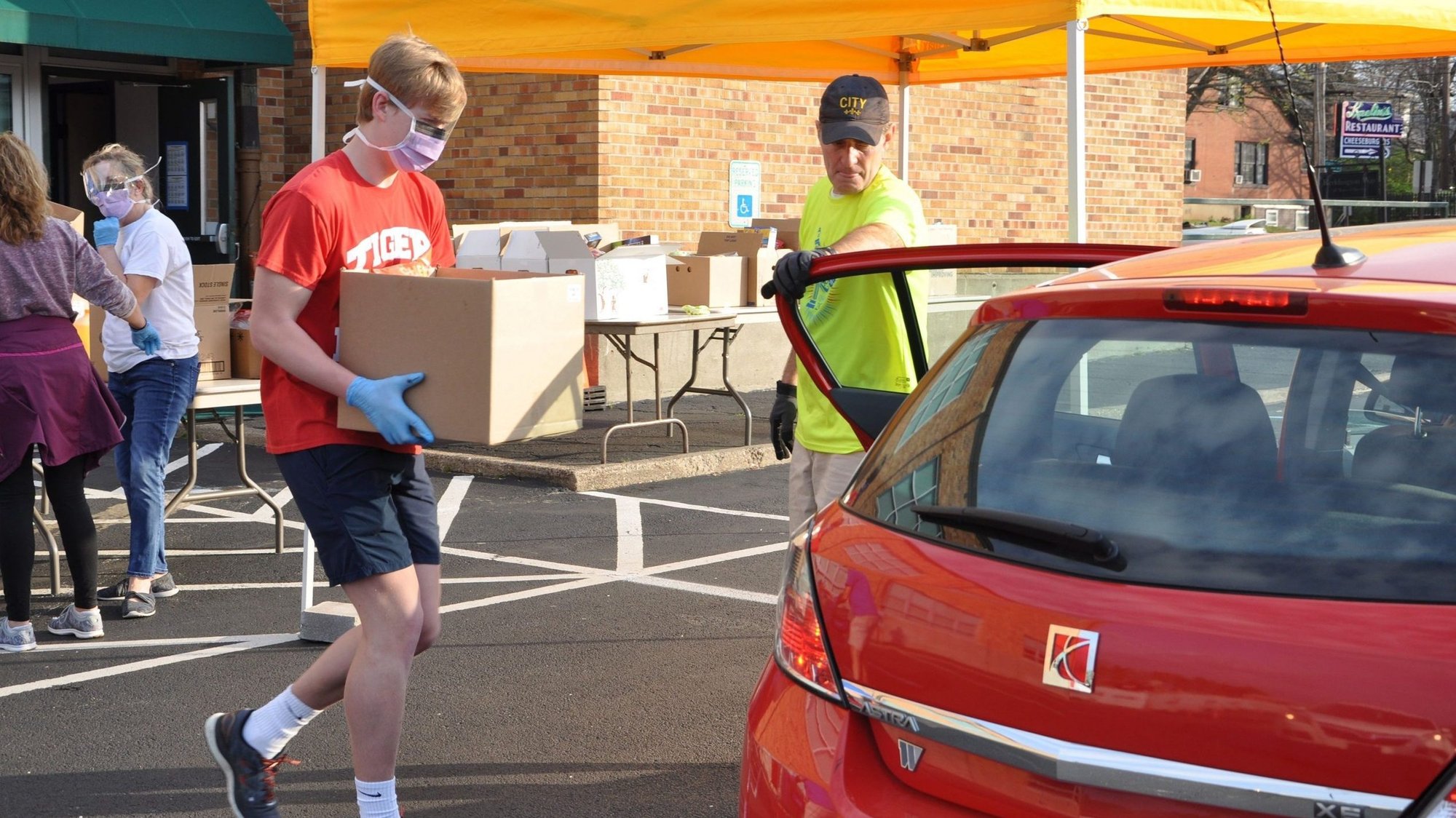 Erik von Nostitz and David Schuler load groceries into a car at St. Agnes Church's Dare to Care Food Pantry March 28, 2020, in Louisville, Ky., during the coronavirus pandemic. (CNS photo/Jessica Able, The Record)