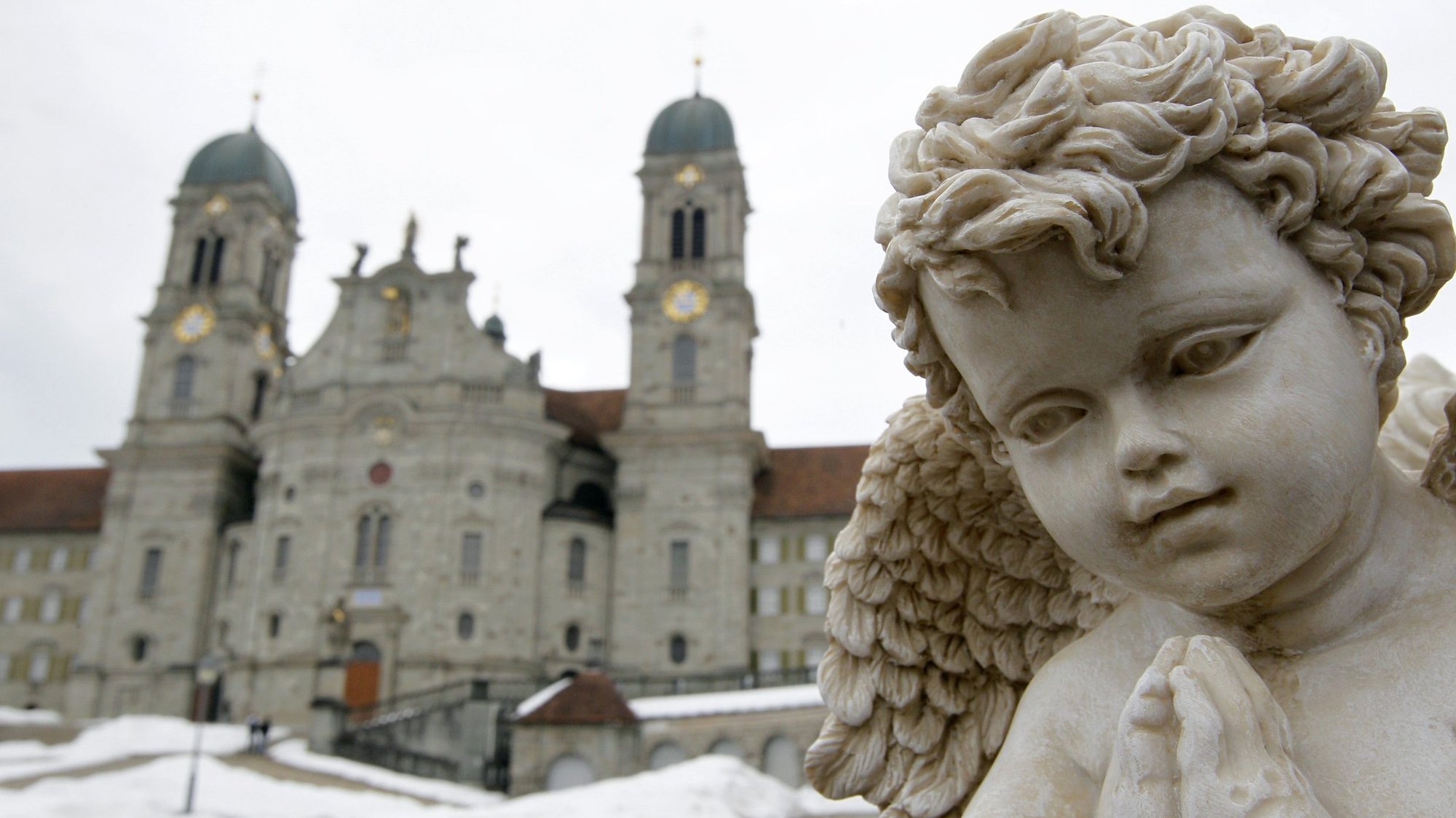 A statues of a cherub is displayed at a souvenir shop in front of the main entrance to the church of the Benedictine Abbey of Einsiedeln in Switzerland March 20, 2010. That year, officials in at the abbey confirmed allegations of child abuse of former pupils at the abbey's school, dating to the 1970s. (CNS photo/Christian Hartmann, Reuters)