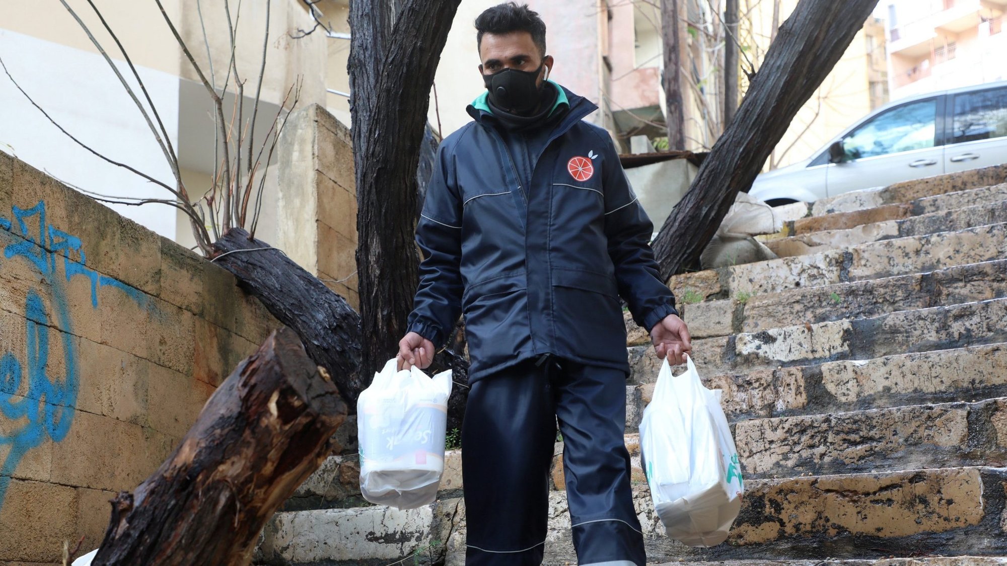 A delivery worker from the mobile app Toters carries plastic bags of groceries in Beirut in this Jan. 20, 2021, file photo. For more than 130 years, popes have made the dignity of workers a moral issue, a tradition continued by Pope Francis. (CNS photo/Mohamed Azakir, Reuters)
