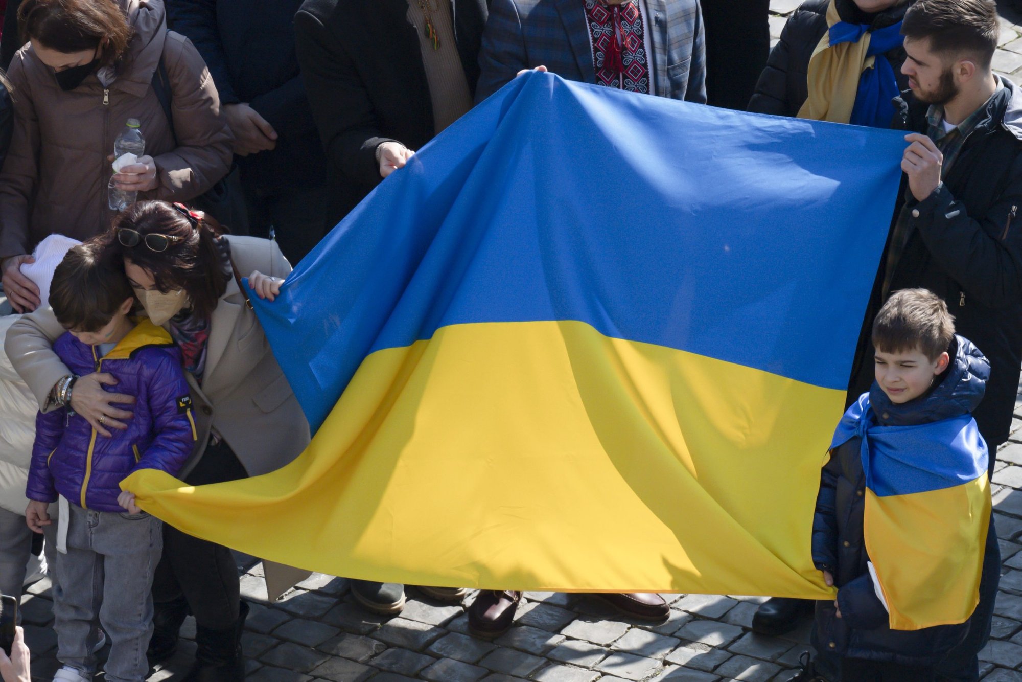 People holds Ukraine's flag in St. Peter's Square as Pope Francis leads the Angelus from the window of his studio overlooking the square at the Vatican March 6, 2022. In his Angelus message, the pope said the Vatican "is ready to do everything to put itself at the service of peace" in Ukraine. (CNS photo/Vatican Media)
