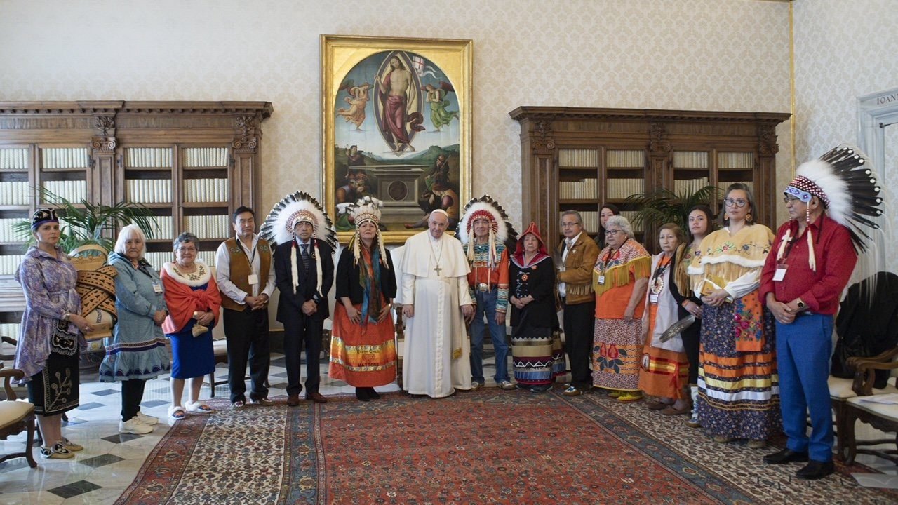 Pope Francis is pictured with Assembly of First Nations delegates during a meeting at the Vatican March 31, 2022. The delegate on the left is holding a "cradleboard," a baby carrier that the delegates asked the pope to keep overnight to remember the Indigenous children sent to residential schools. (CNS photo/Vatican Media)
