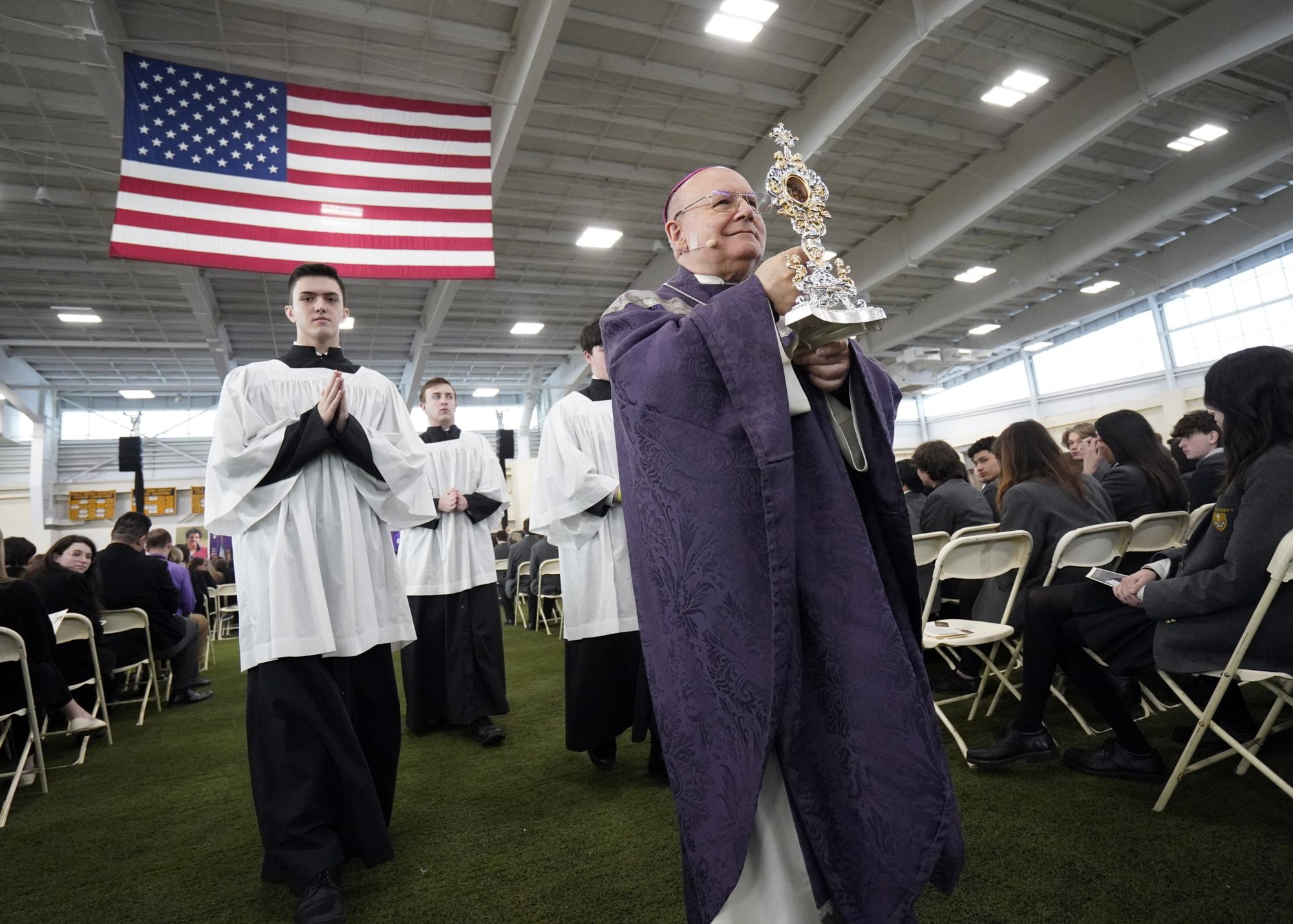 Archbishop Domenico Sorrentino of Assisi-Nocera Umbra-Gualdo Tadino, Italy, processes with a reliquary containing a relic of Blessed Carlo Acutis during Mass at St. Anthony's High School in South Huntington, N.Y., April 4, 2022. Archbishop Sorrentino was visiting the New York metropolitan area with the relic during a five-day trip to the U.S. Blessed Acutis, an Italian teen who died in 2006 and was beatified in 2020, is entombed in the Church of Santa Maria Maggiore in Assisi. (CNS photo/Gregory A. Shemitz)