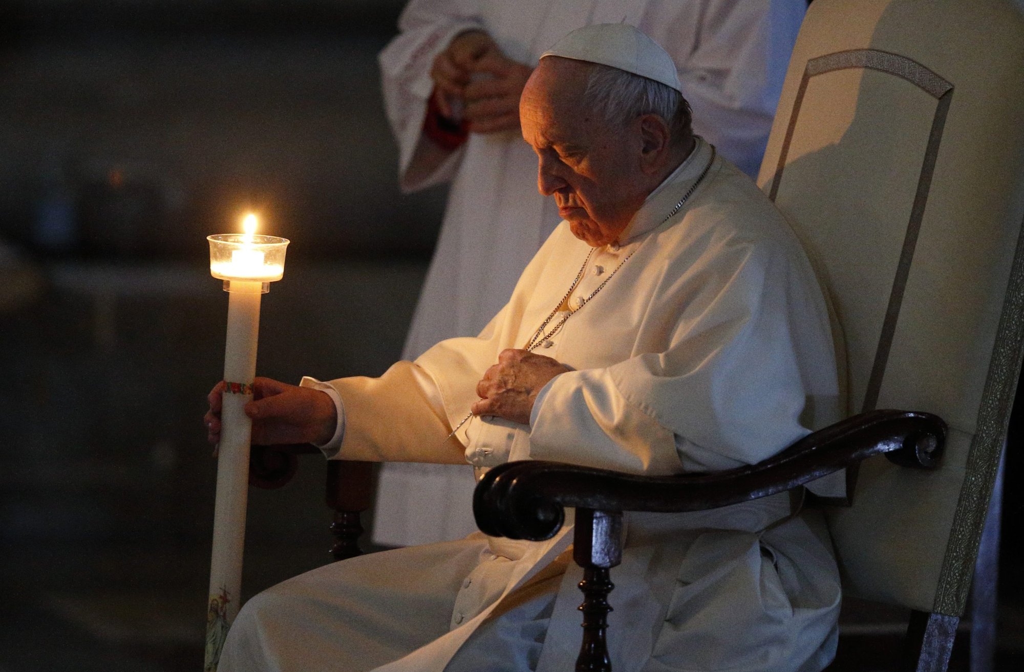 Pope Francis holds a candle as he attends the Easter Vigil celebrated by Cardinal Giovanni Battista Re in St. Peter's Basilica at the Vatican April 16, 2022. (CNS photo/Paul Haring)