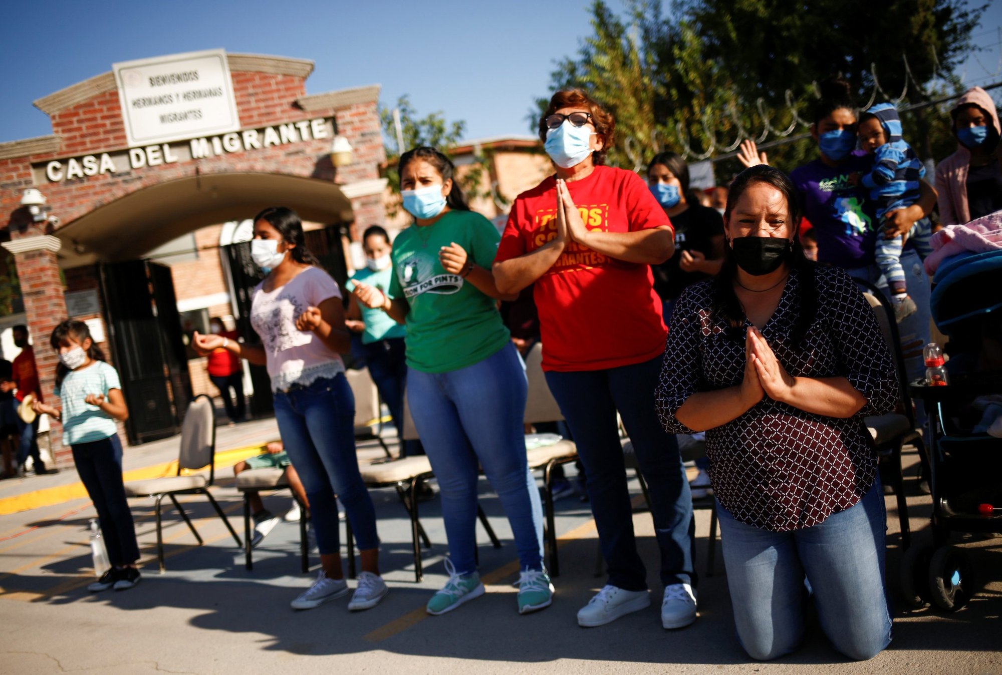 Migrants pray during an outdoor Mass in celebration of the World Day of Migrants and Refugees at Casa del Migrante shelter in Ciudad Juarez, Mexico, Sept. 19, 2021. Pope Francis will celebrate World Day of Migrants and Refugees at the Vatican Sept. 25 this year. (CNS photo/Jose Luis Gonzalez, Reuters)