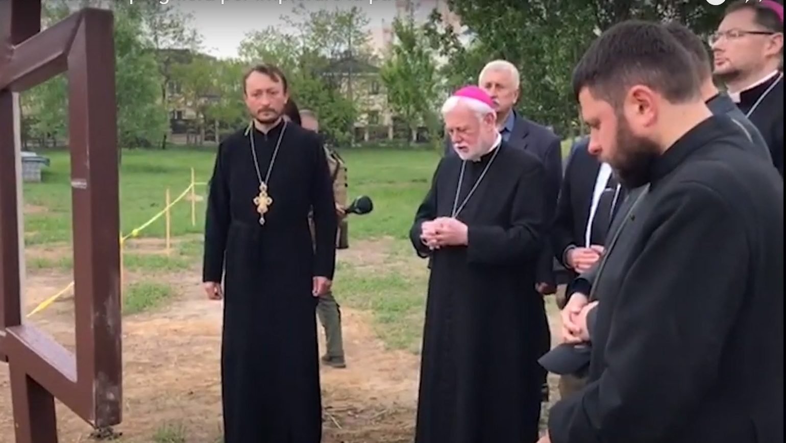 Archbishop Paul R. Gallagher, Vatican foreign minister, prays at the site of a mass grave near the Orthodox Church of St. Andrew in Bucha, Ukraine, May 20, 2022, in this still image taken from video posted by the Vatican. (CNS photo/Vatican Media)
