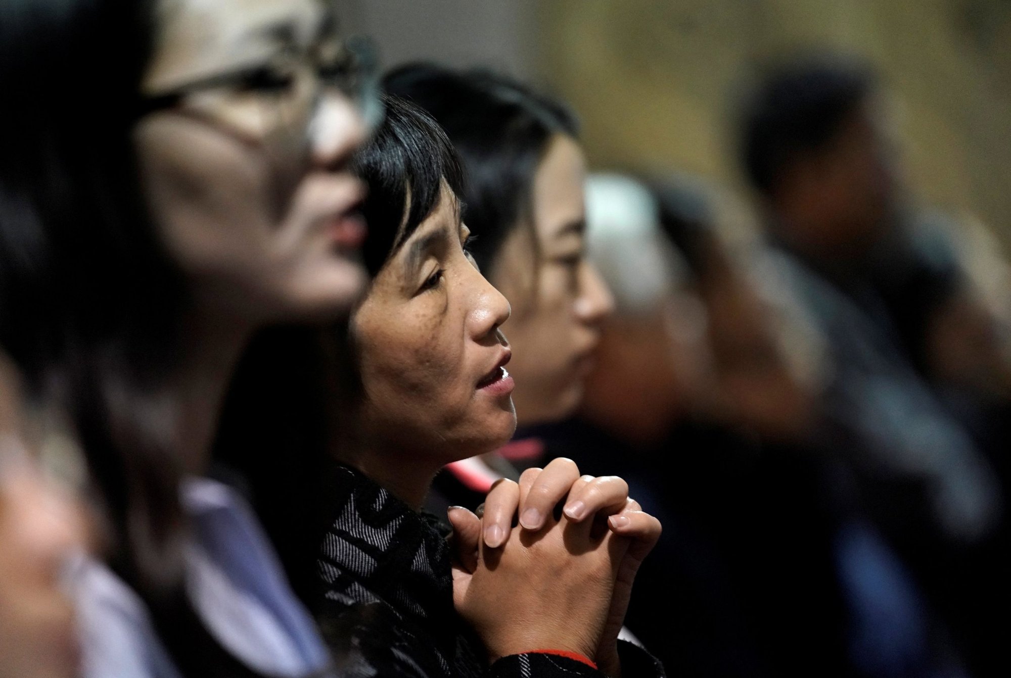 A woman is seen praying during Mass at a church in Beijing Sept. 29, 2018. Bishop Joseph Zhang Weizhu of Xinxiang -- a Vatican-approved Chinese prelate --remains in detention more than one year after his arrest, accused of violating the communist country's regulations on religious affairs. (CNS photo/Jason Lee, Reuters)