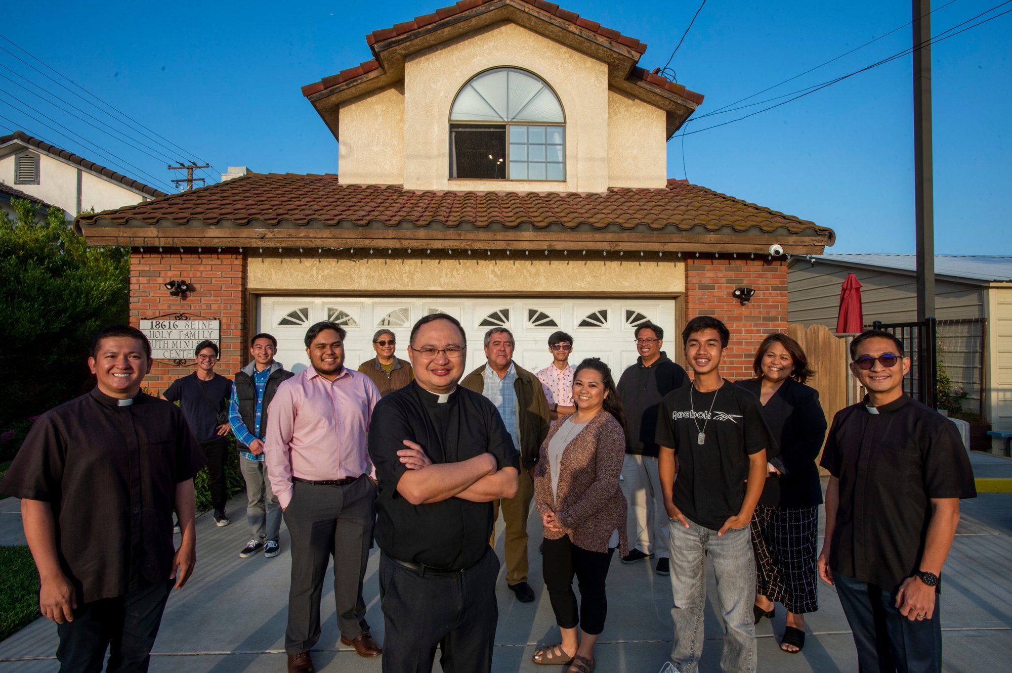 Father John Cordero (center) and volunteers stand in front of the new Blessed Carlo Acutis Broadcast Center next to Holy Family Church in Artesia, the parish where he is pastor. (Mike Goulding)