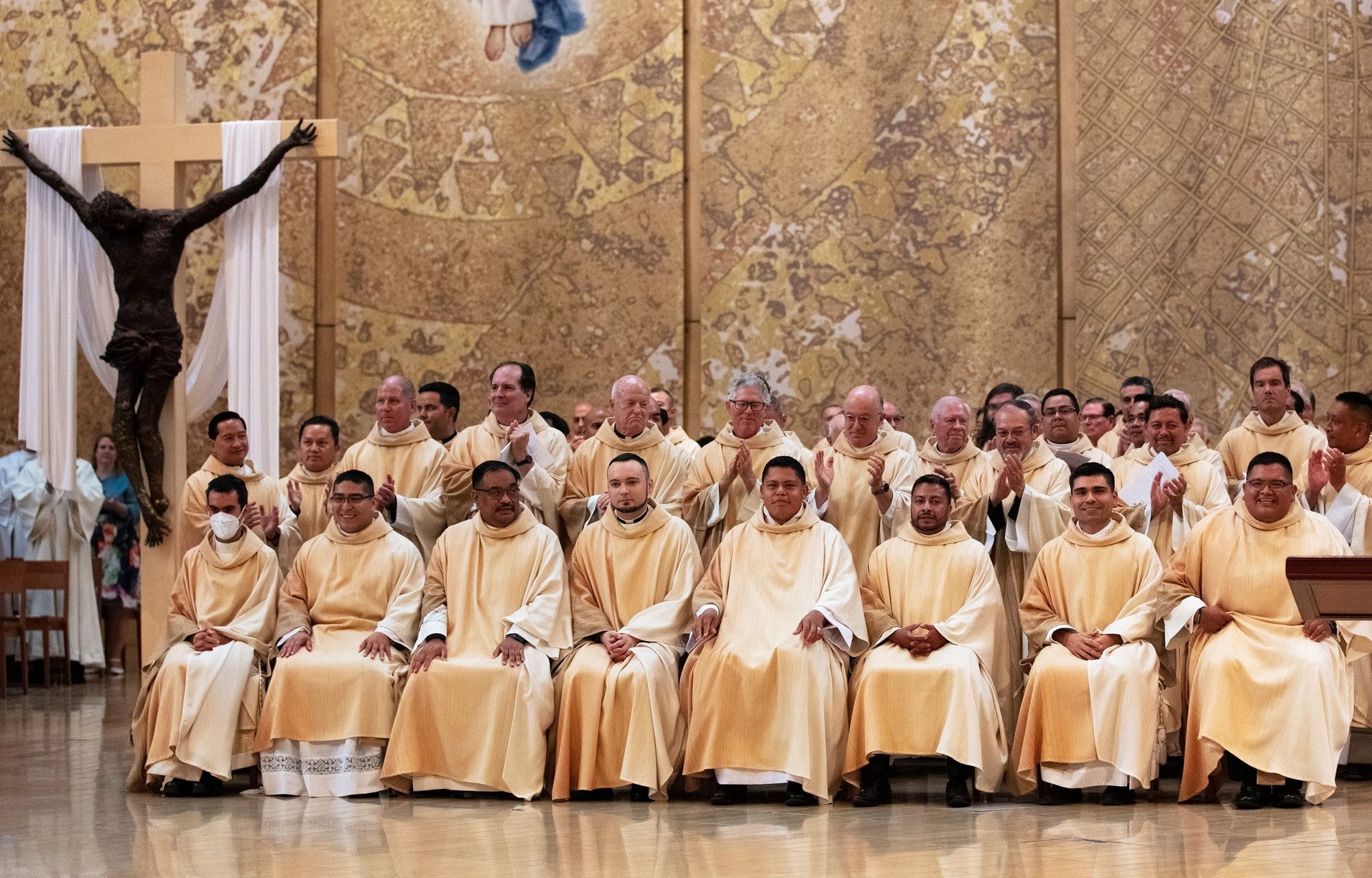 From left: Newly ordained priests Daniel Vega, Daniel Lopez, Justin Ordoveza, Kamil Ziolkowski, Ramon Reyes, Juan Gutierrez, Juan Martinez, and Guillermo “Memo” Alonso get a standing ovation at the Ordination Mass on June 4, 2022. (Victor Alemán)