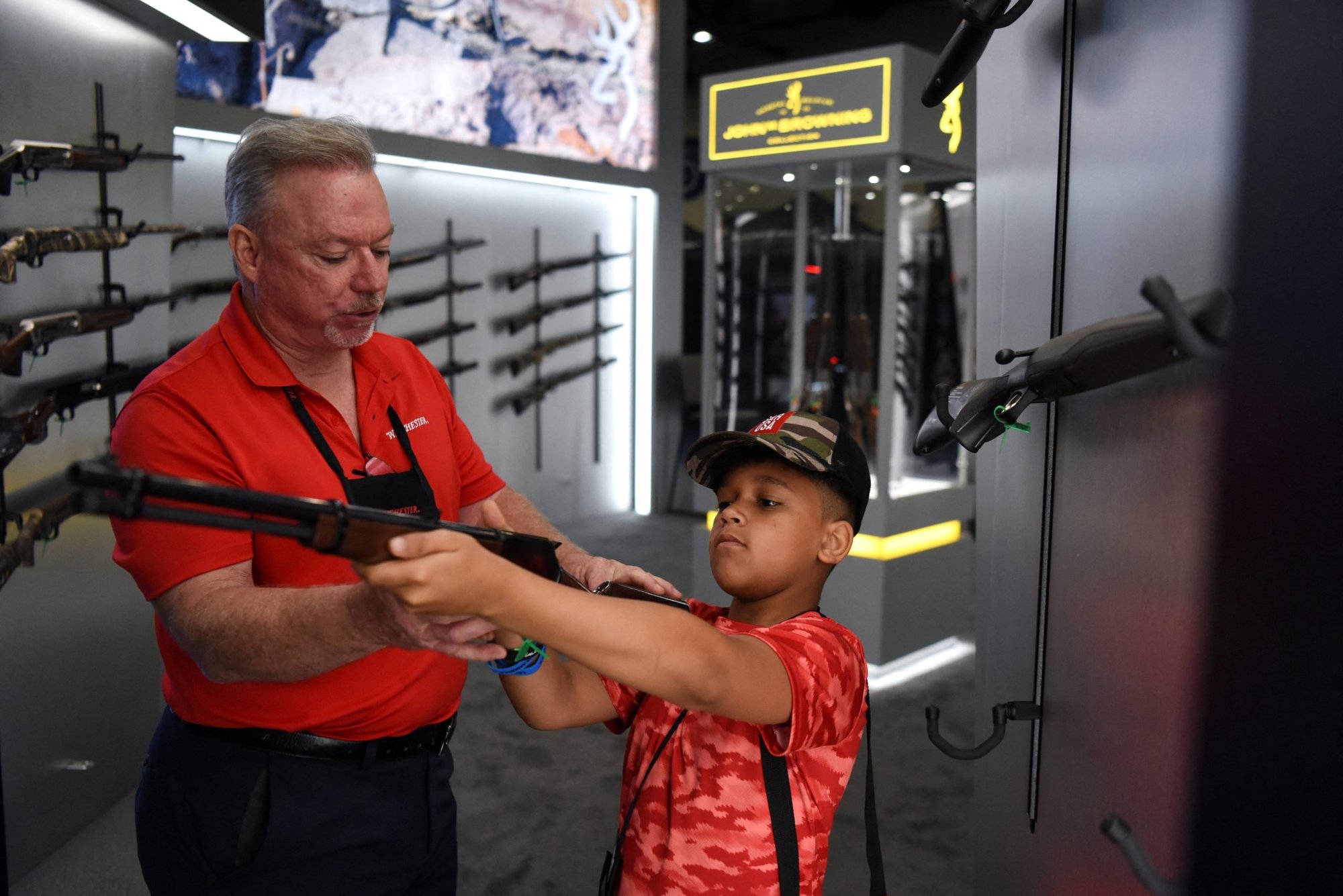 A child in Houston holds a firearm on display May 29, 2022, at the National Rifle Association's annual convention. (CNS photo/Callaghan O'Hare, Reuters)