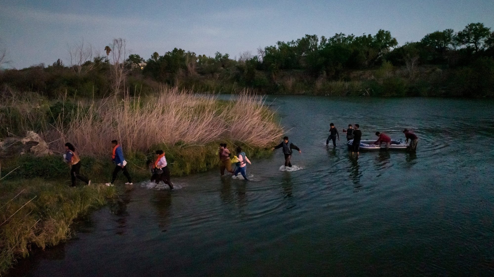 Migrants from Central and South America exit their raft onto an island in the middle of Rio Grande near Roma, Texas, June 11, 2022. (CNS photo/Adrees Latif, Reuters)