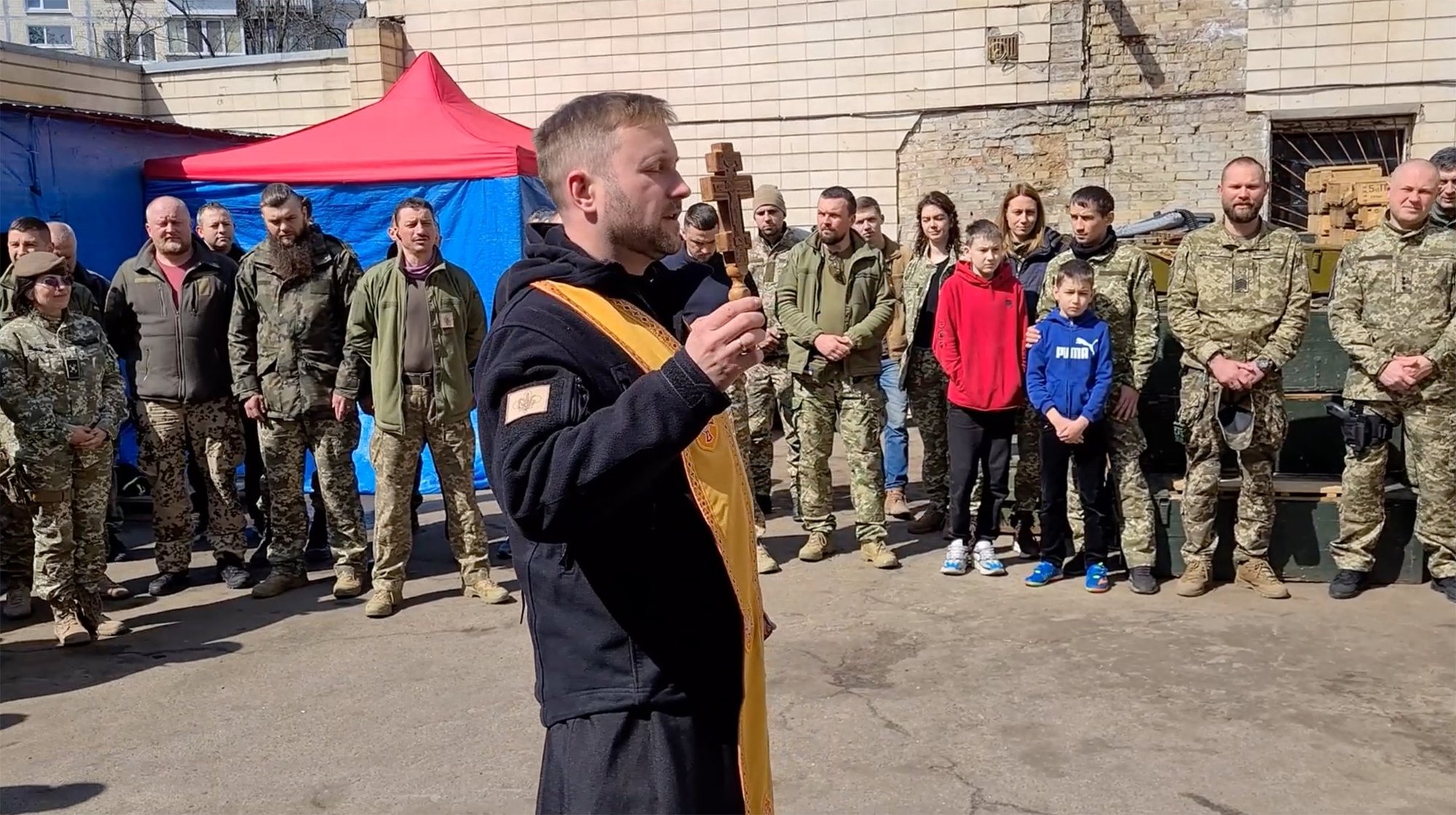 Father Rostyslav Vysochan, a military chaplain, prays with soldiers in an undisclosed location in Ukraine in June 2022. (CNS photo/Voznyak Production)
