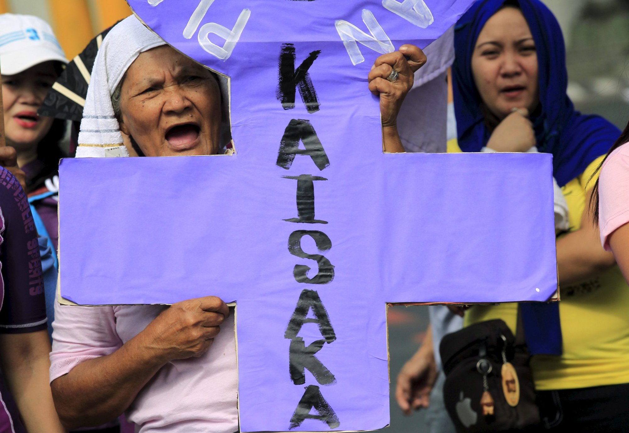 An activist holds a placard shouting anti-government slogans while protesting outside the presidential palace in Manila March 8, 2016. In a statement on July 17, 2022, the religious superiors in the Philippines said "red-tagging" would not deter them from criticizing the regime of President Ferdinand Marcos Jr., on issues such as corruption and graft. (CNS photo/Romeo Ranoco, Reuters)