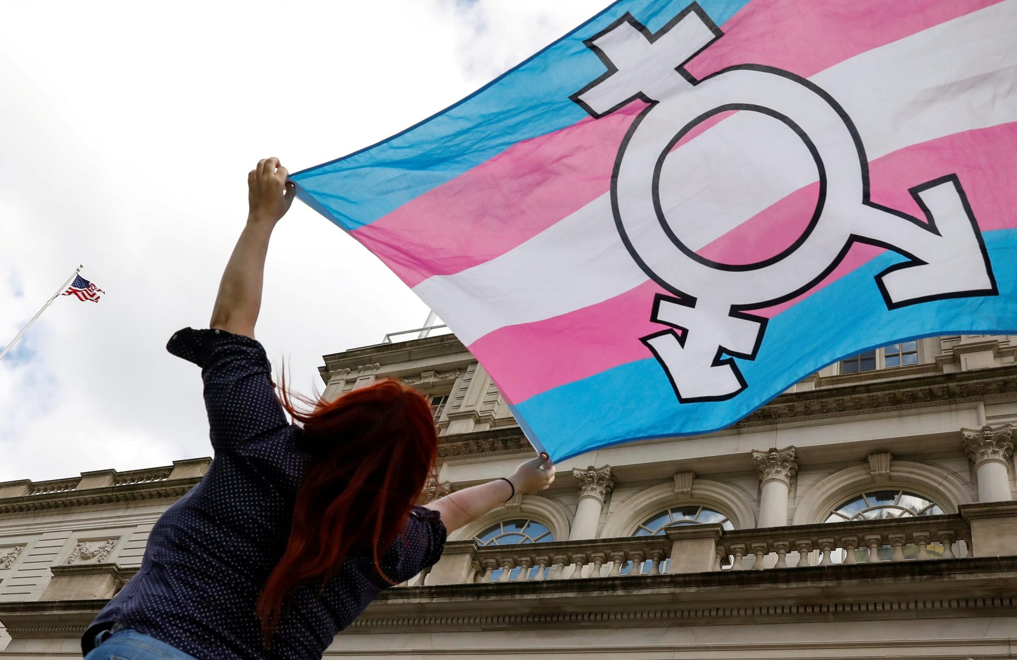 A person in New York City holds up a flag Oct. 24, 2018, to protest a policy by the then-Trump administration to define sex as an individual's status as male or female based on traits identified at birth. (CNS photo/Brendan McDermid, Reuters)