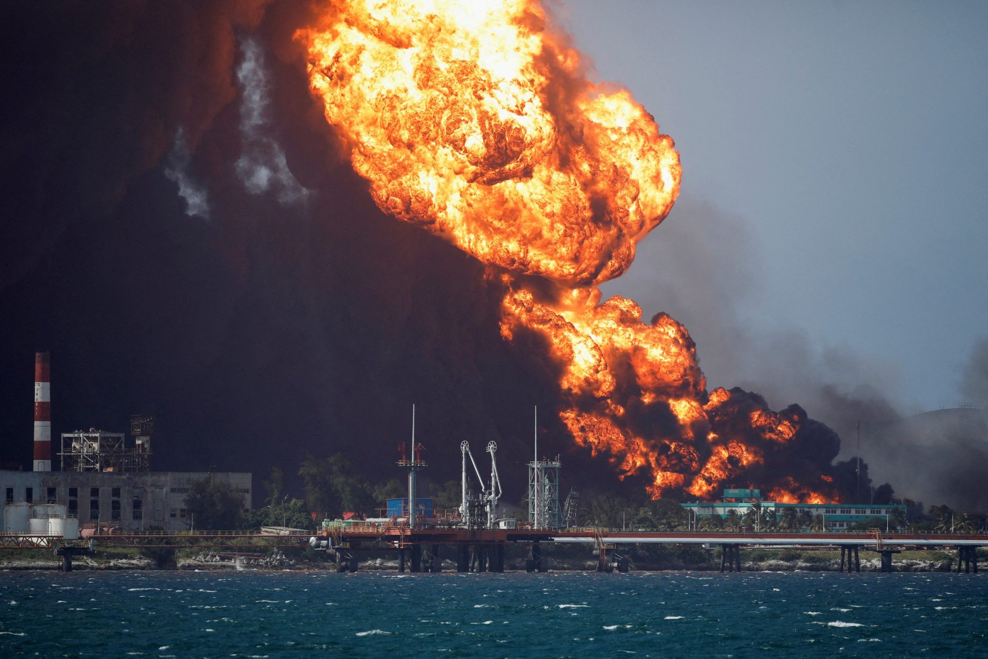 Smoke and fire billow over a large oil storage facility that exploded near Cuba's supertanker port in Matanzas Aug. 8, 2022. The deadly fire is threatening to plunge the island into a deeper energy crisis as it forced officials to shut down a key thermoelectric plant. (CNS photo/Alexandre Meneghini, Reuters)