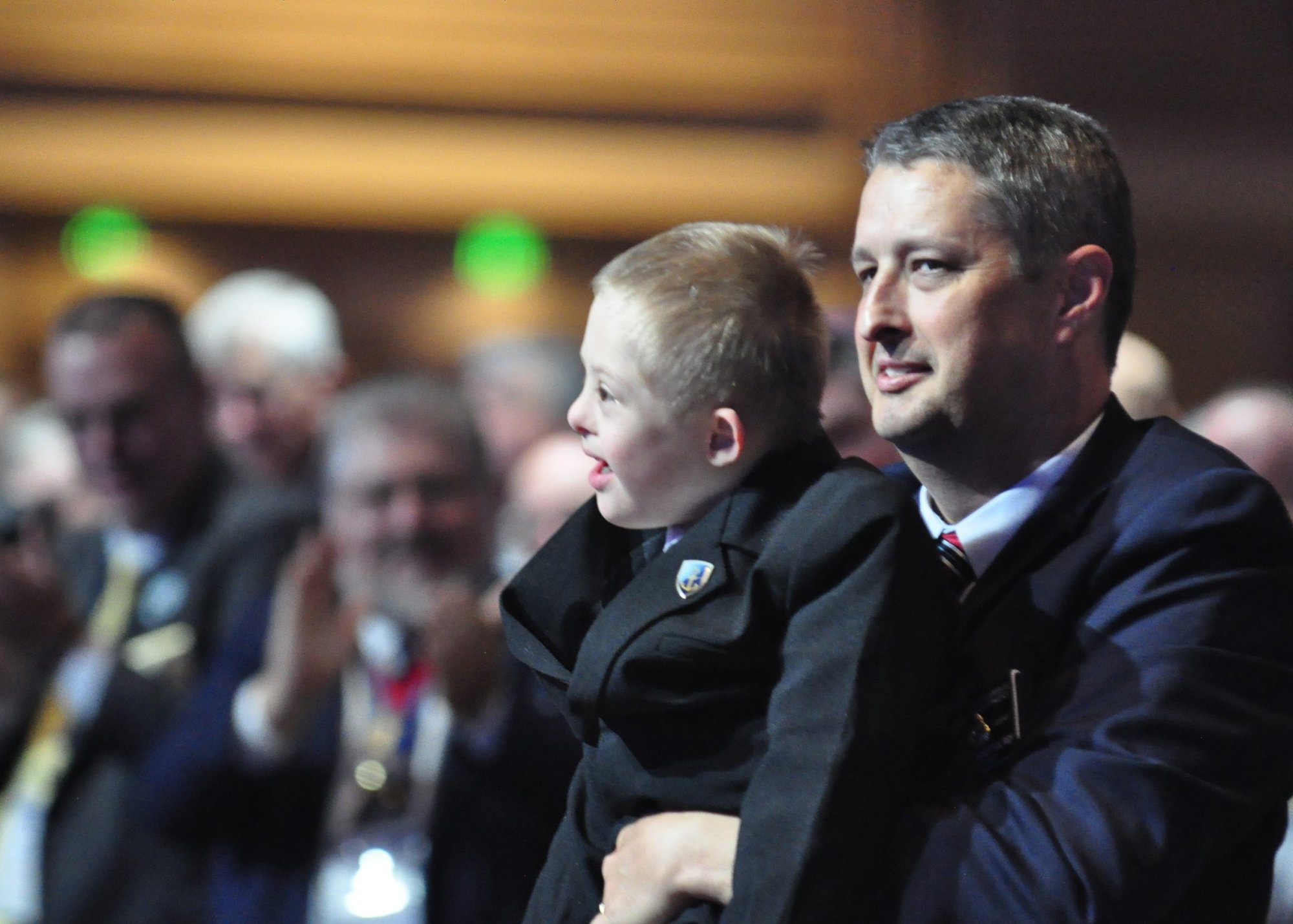 Dan Schachle of Dickson, Tenn., holds his son Mikey Aug. 2, 2022, during the opening session of the 140th Knights of Columbus Supreme Convention in Nashville. Mikey's cure from a deadly case of fetal hydrops was proclaimed a miracle due to the intercession of Father Michael McGivney, founder of the Knights, opening the door to the priest's beatification in 2020. (CNS photo/Andy Telli, Tennessee Register)