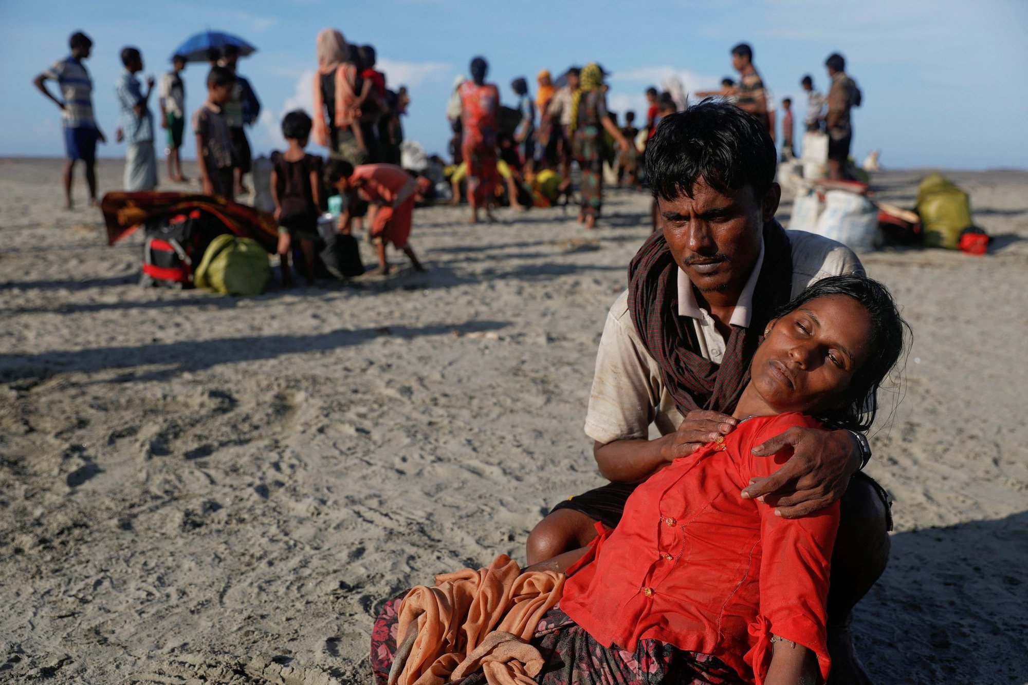 A man who said his village was burned and relatives killed by Myanmar soldiers comforts his wife as Rohingya refugees arrive by a wooden boat from Myanmar in Shah Porir Dwip, Bangladesh, Oct. 1, 2017. (CNS photo/Damir Sagolj, Reuters)