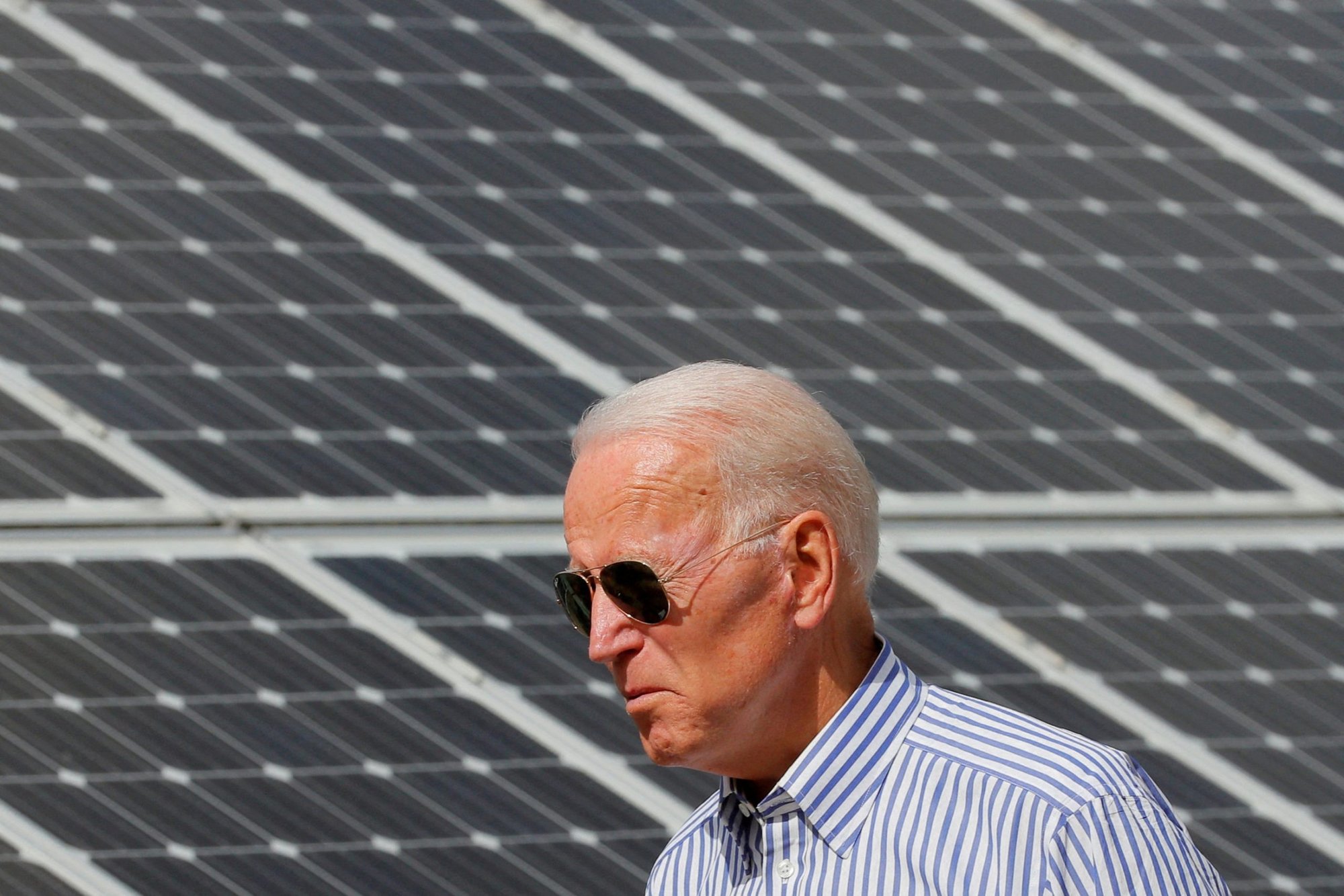 In this 2019 file photo, then-presidential candidate Joe Biden walks past solar panels while touring the Plymouth Area Renewable Energy Initiative in Plymouth, N.H. (CNS photo/Brian Snyder, Reuters)