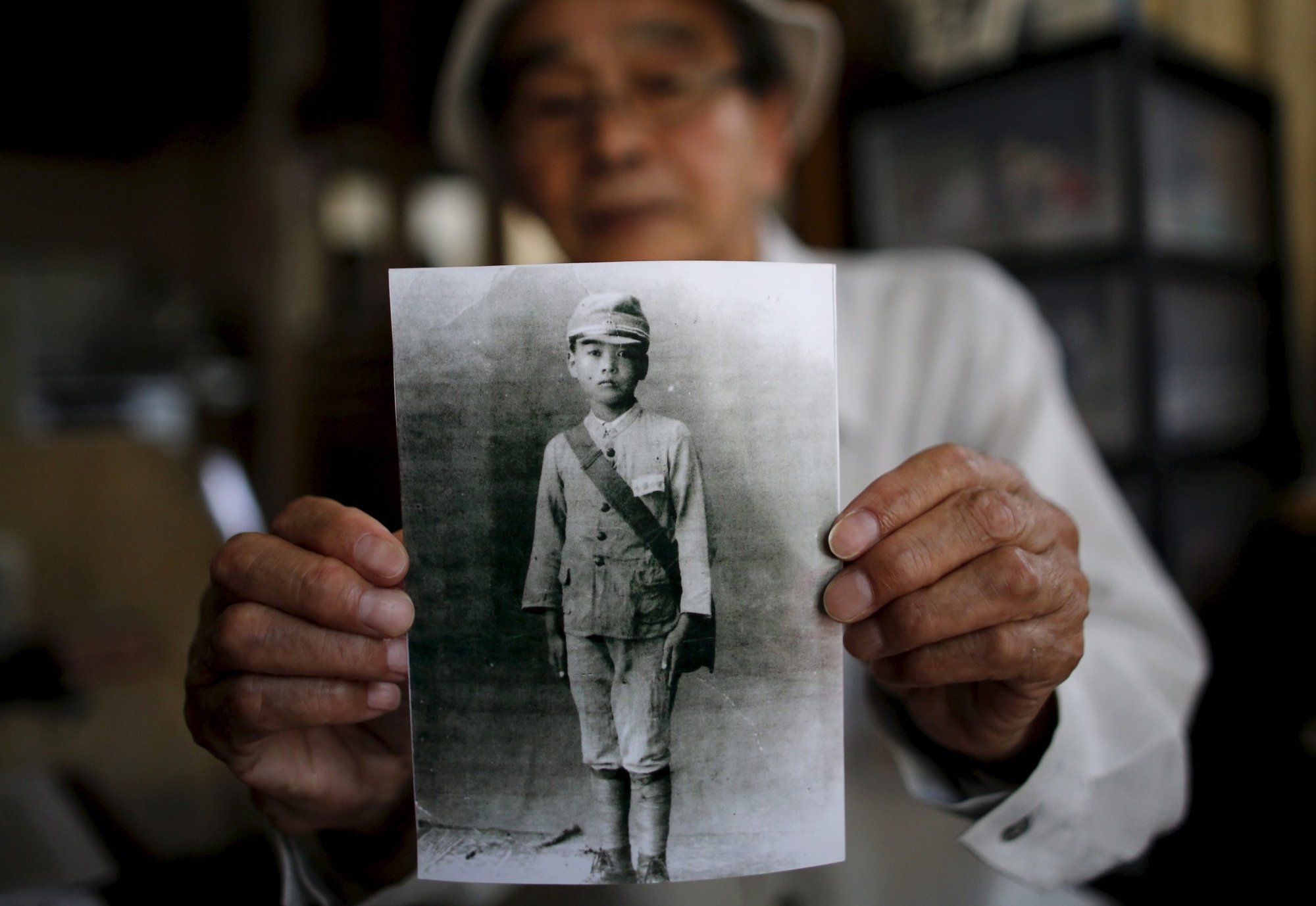 Yoshiteru Kohata, an 86-year-old Nagasaki atomic bombing survivor and retired schoolteacher, poses July 31, 2015, at his home in Miharu, Japan, as he holds a portrait taken when he was in middle school. (CNS photo/Toru Hanai, Reuters)