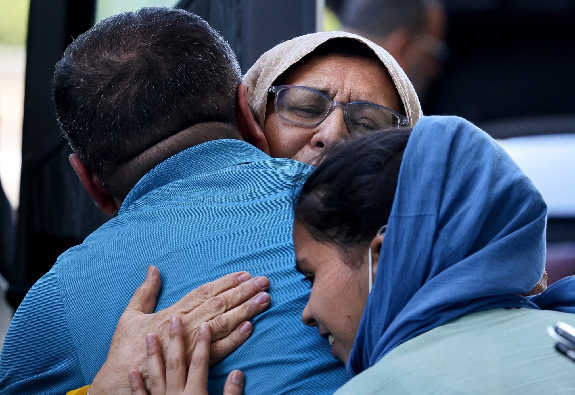 Afghan refugees embrace family members after arriving at Dulles International Airport in Dulles, Va., Sept. 2, 2021, before boarding buses that will take them to a processing center. (CNS photo/Evelyn Hockstein, Reuters)
