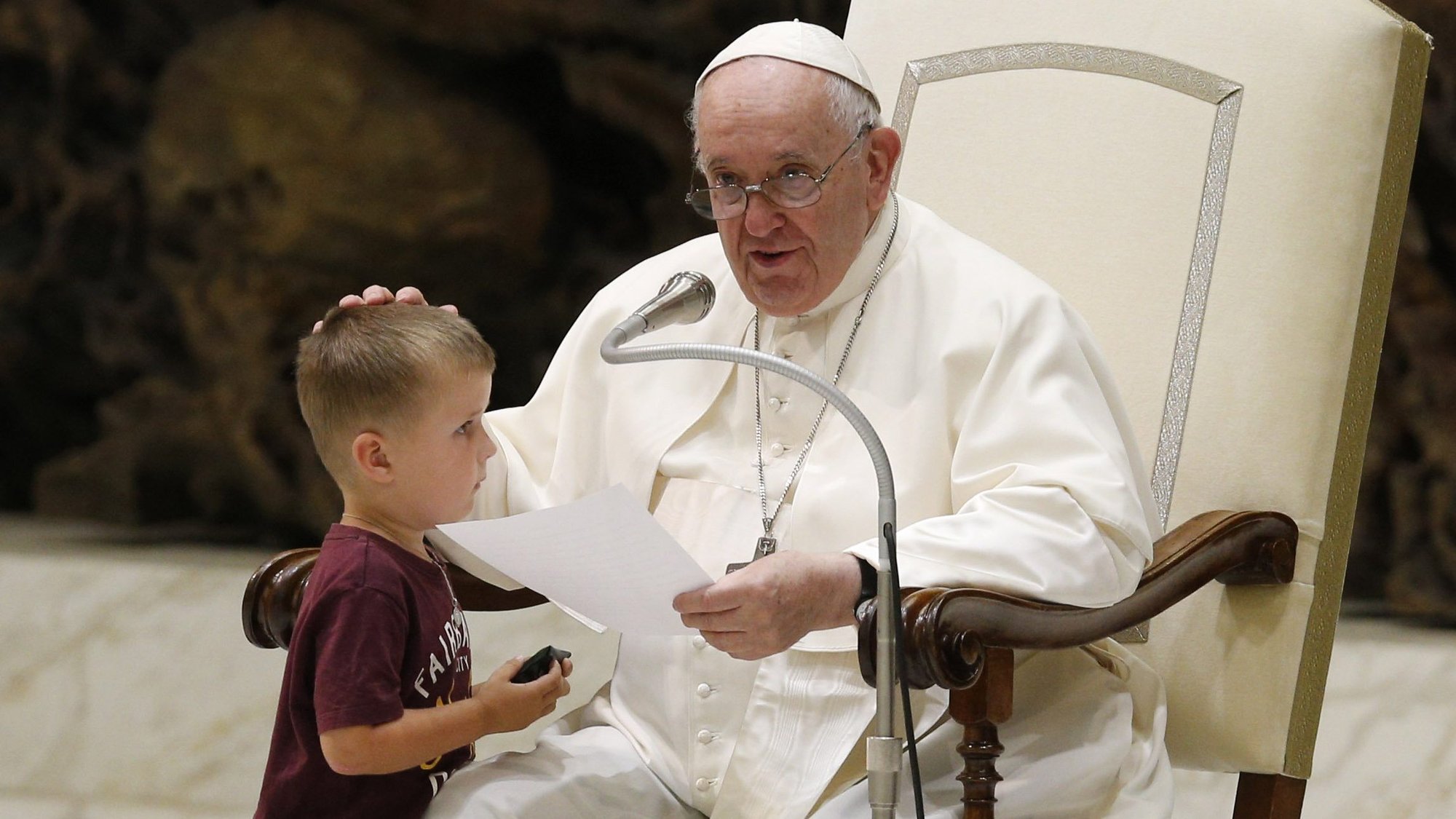 Pope Francis greets a boy who ran onstage during his general audience in the Paul VI hall at the Vatican Aug. 17, 2022. (CNS photo/Paul Haring)