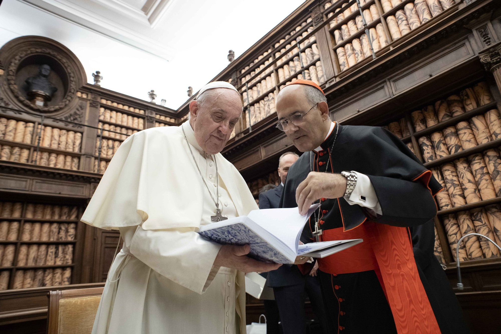 Pope Francis talks with Cardinal José Tolentino Calaca de Mendonca, Vatican archivist and librarian, during a ceremony in the Vatican Library Nov. 5, 2021. The Vatican Library, one of the world's oldest libraries, has launched a new scholarly journal to help promote high-quality research, dialogue across cultures and sharing knowledge, said Cardinal Mendonca. (CNS photo/Vatican Media)