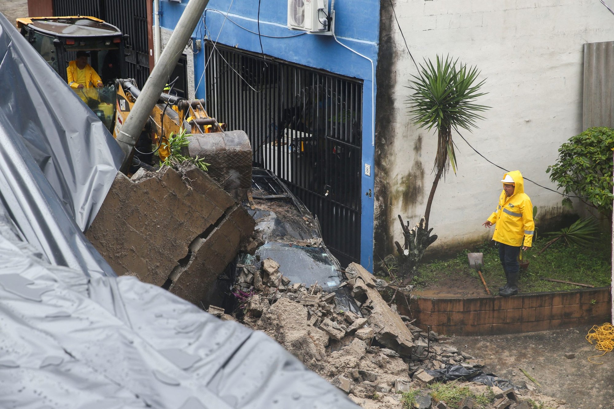 A worker observes a car damaged in a landslide after the impact of Tropical Storm Julia in Antiguo Cuscatlán, El Salvador, Oct. 10, 2022. Hurricane Julia directly made landfall in Nicaragua, but left a trail of destruction and reported deaths in Honduras and El Salvador as it weakened into a tropical storm. (CNS photo/Jose Cabezas, Reuters)