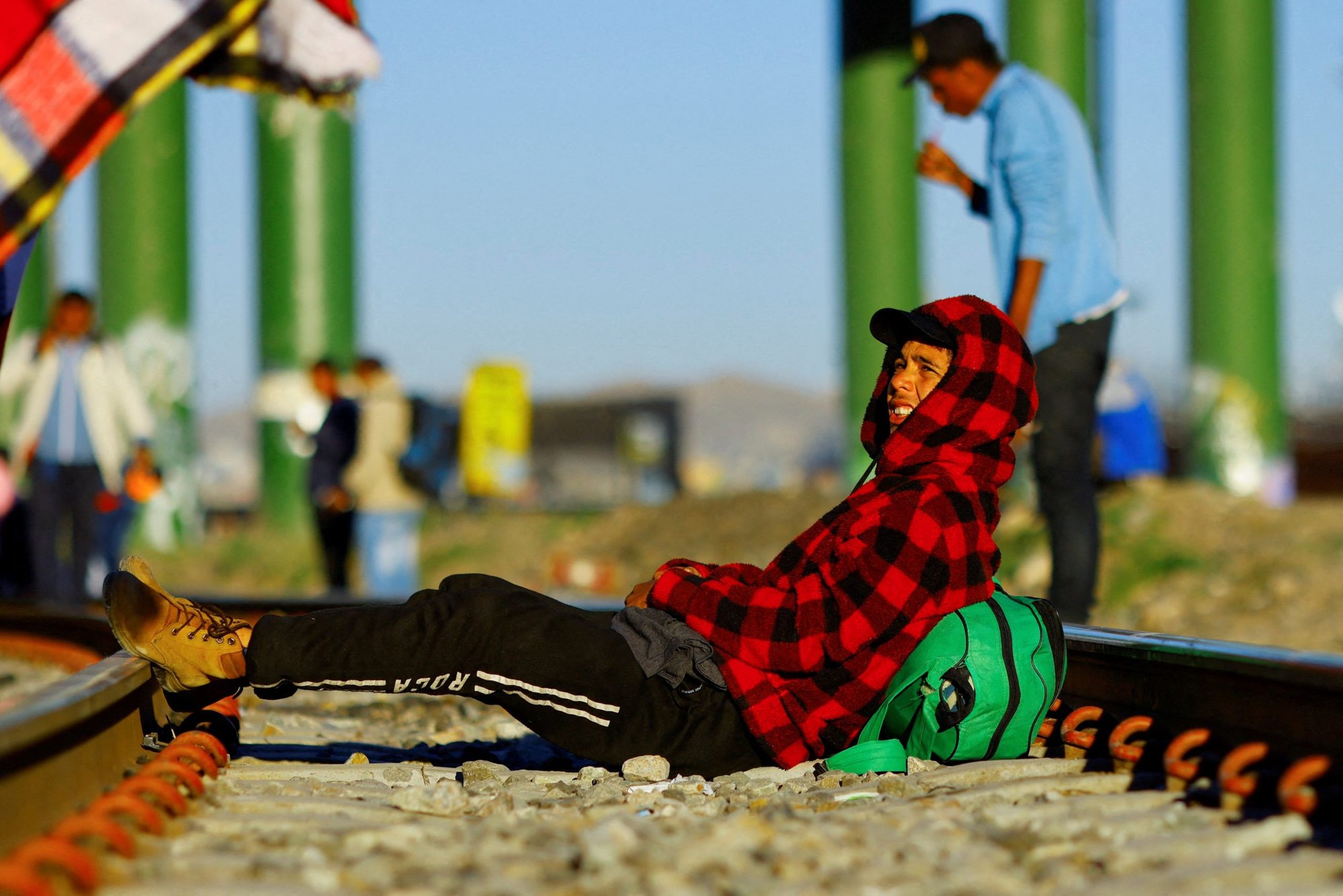 Leonardo Martinez, a migrant from Venezuela who has not crossed into the U.S. due to the new immigration policies, rests on the train tracks near the Paso del Norte International border bridge in Ciudad Juarez, Mexico Oct. 20, 2022.(CNS photo/Jose Luis Gonzalez, Reuters)