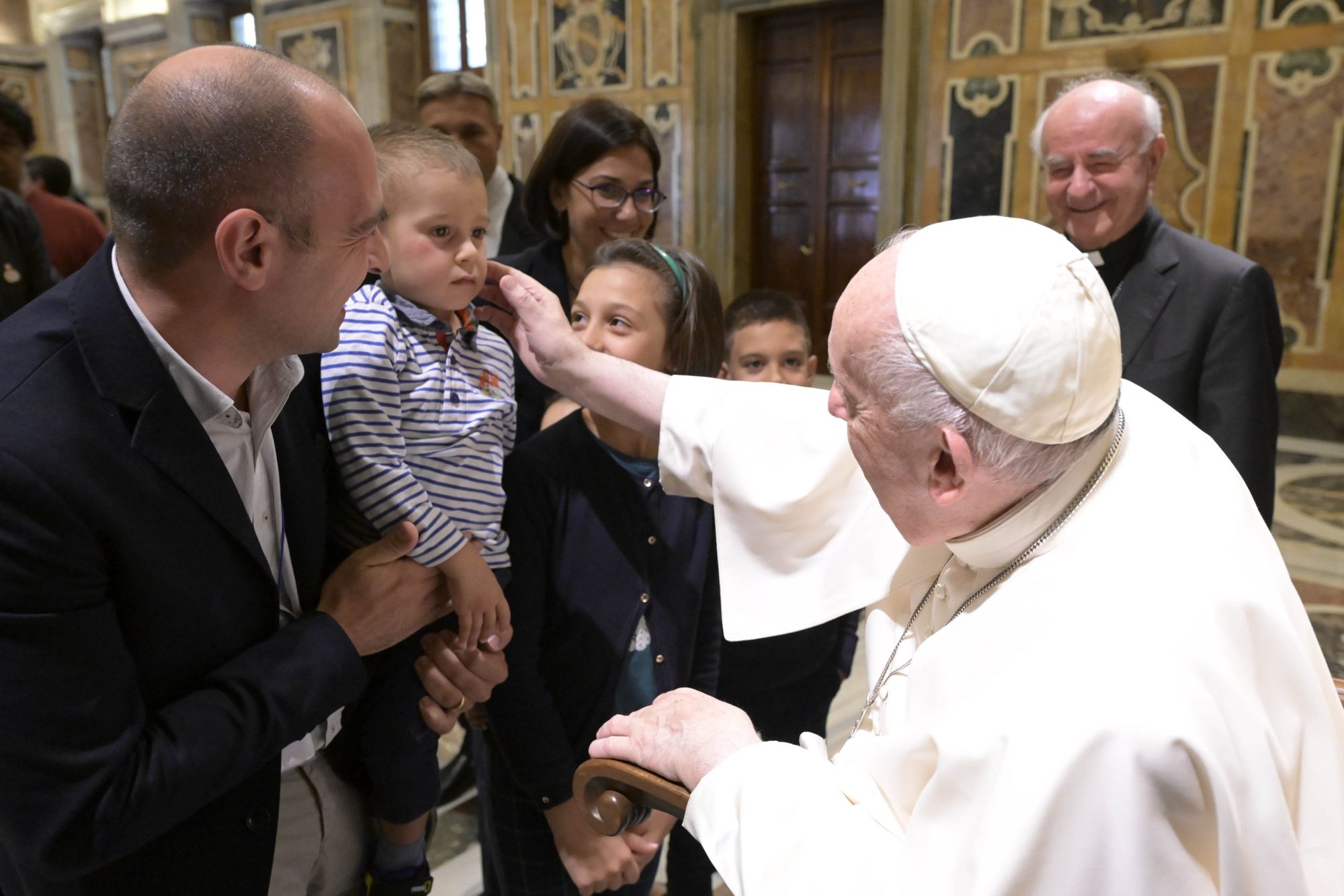 Pope Francis caresses the cheek of a child during an audience Oct. 24, 2022, with students and staff of the Pontifical John Paul II Theological Institute for the Sciences of Marriage and Family in the Vatican's Clementine Hall. (CNS photo/Vatican Media)