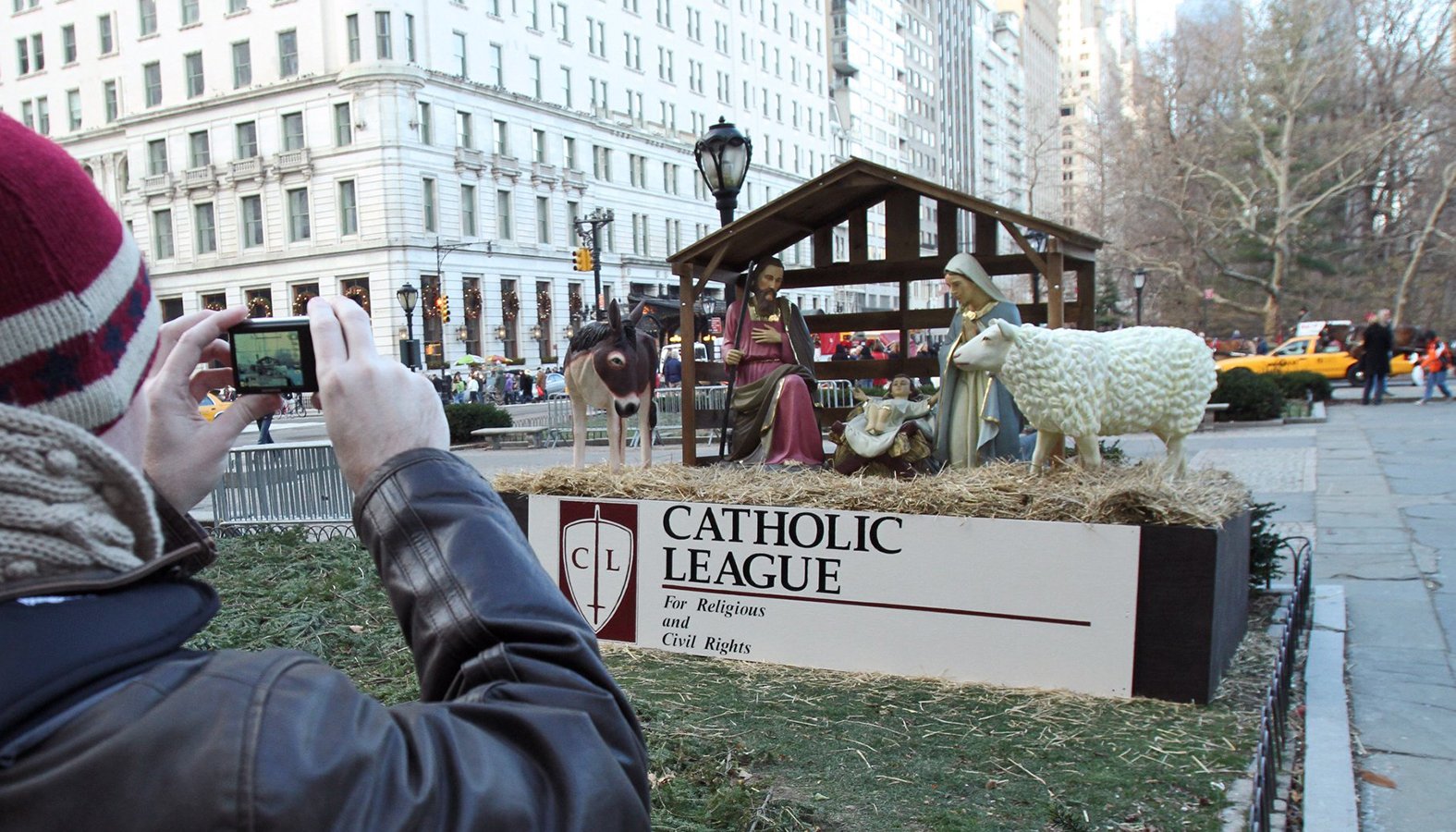 A man takes a photo of a crèche, erected by the New York-based Catholic League for Religious and Civil Rights, at an entrance to Central Park in New York City in 2010. (CNS/Gregory A. Shemitz)
