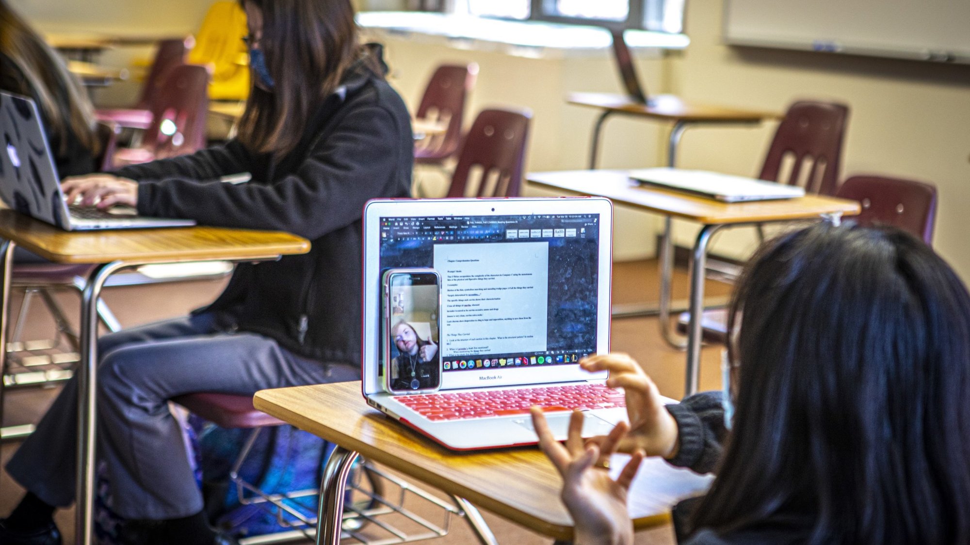 Catholic high school student Minjie Paark talks to her fellow student Molly Shapiro on her smartphone through FaceTime as they participate in class at Padua Academy in Wilmington, Del., March 30, 2021. The students learning virtually from home joined this particular lesson through smartphone technology. (CNS photo/Chaz Muth)