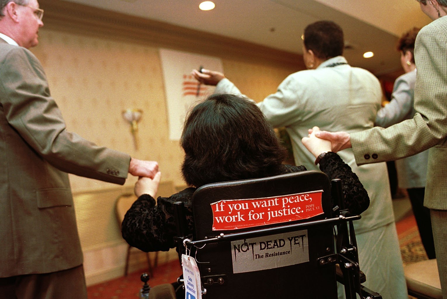 Messages on the back of Lillibeth Navarro's wheelchair announce the causes she works for in her effort to protect and enhance the lives of persons with disabilities, in this 2000 file photo. (CNS/Nancy Wiechec)