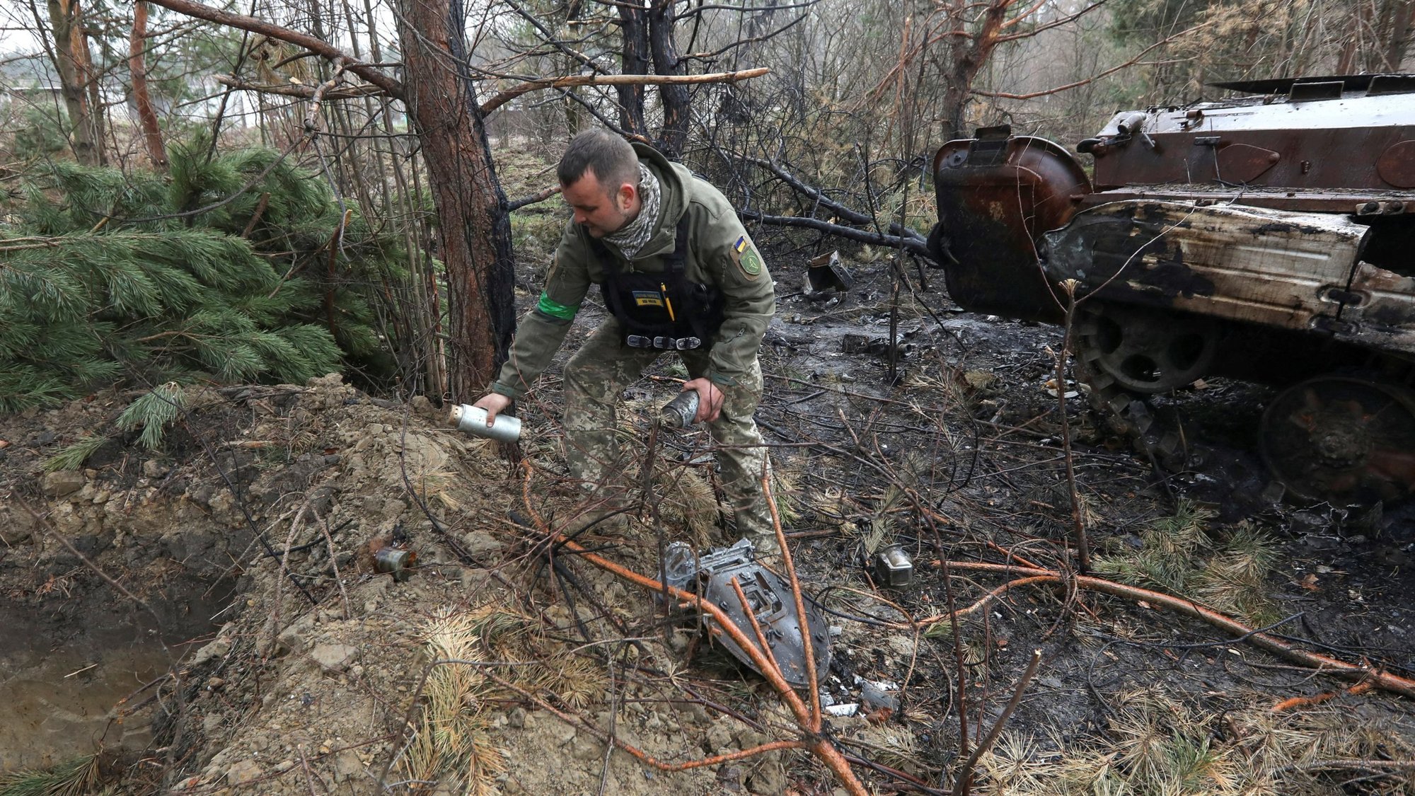 A Ukrainian soldier picks up unexploded parts of a cluster bomb left after Russia's invasion near the village of Motyzhyn, Ukraine, April 10, 2022. In Geneva, during a Sept. 11-14, 2023, meeting. a Holy See delegation urged nations that have not already done so to sign on to the Convention on Cluster Munitions, which "prohibits under any circumstances the use, development, production, acquisition, stockpiling and transfer of cluster munitions." (OSV News/Mykola Tymchenko, Reuters)