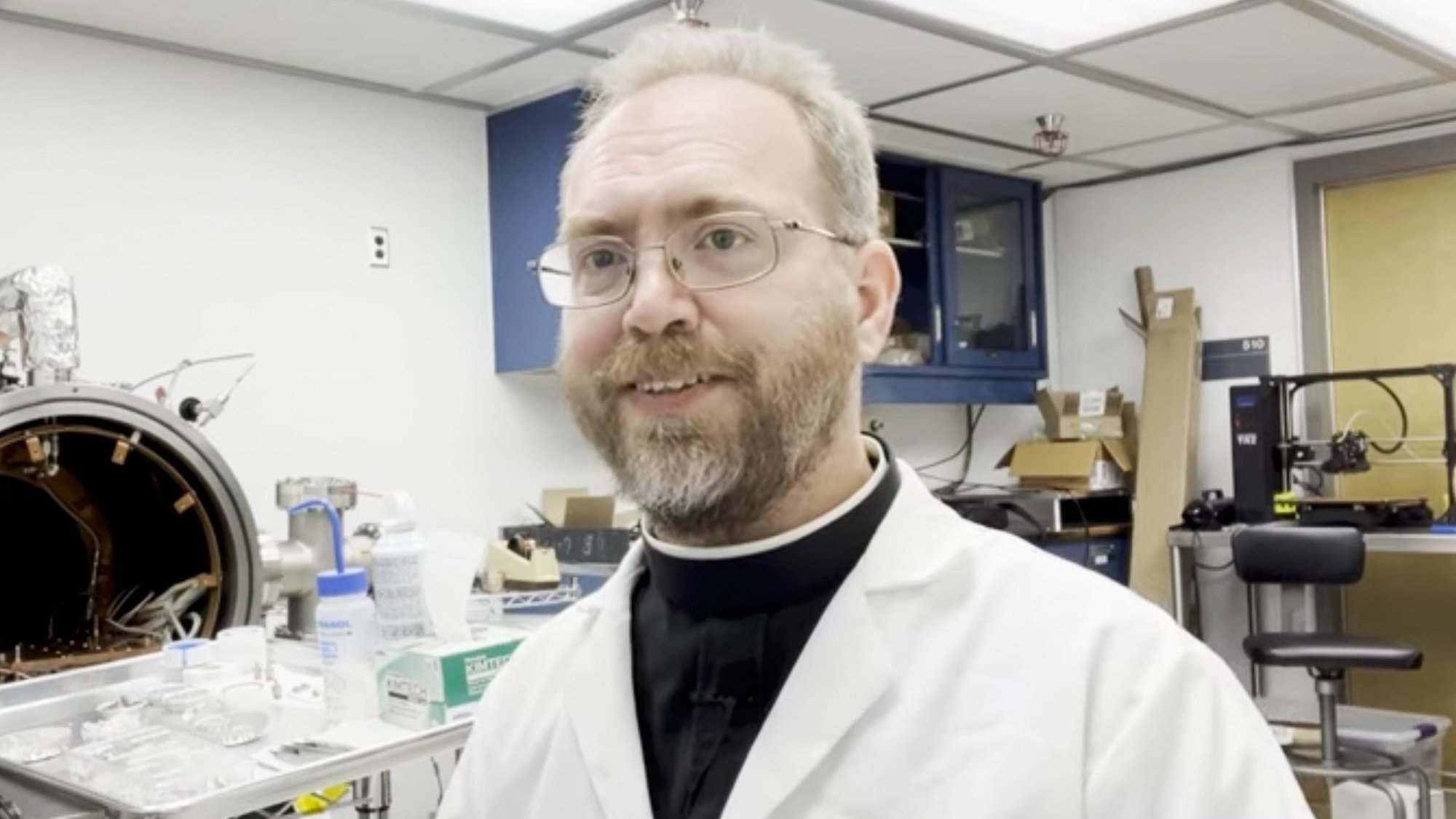 Jesuit Brother Robert Macke presents a device to study the porosity and density of specimens retrieved from the asteroid Bennu by the Osiris-Rex space mission at the Lunar and Planetary Laboratory in Tucson as seen in a YouTube video he posted on his channel Aug 12, 2022. (CNS/YouTube video screenshot)
