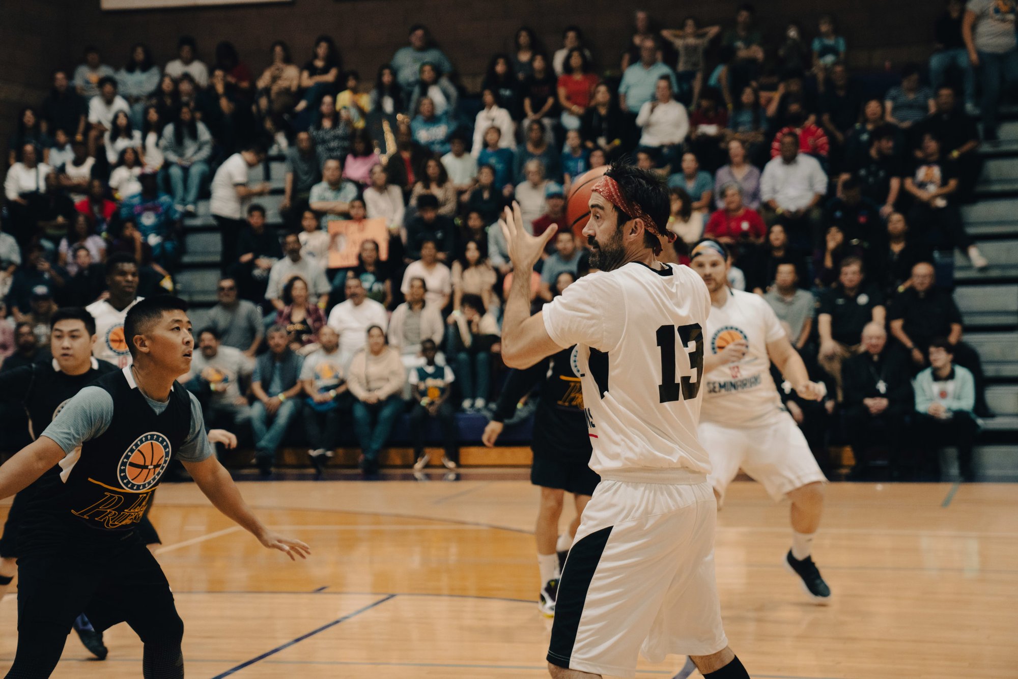 Seminarian Michael Croghan surveys the court at the Priests vs. Seminarians Basketball Game Oct. 13 at Cathedral High School. New logo designs reflecting the look of the NBA’s Los Angeles Lakers and Los Angeles Clippers were incorporated into the priests’ (black) and seminarians’ (white) jerseys. (Peter Lobato)