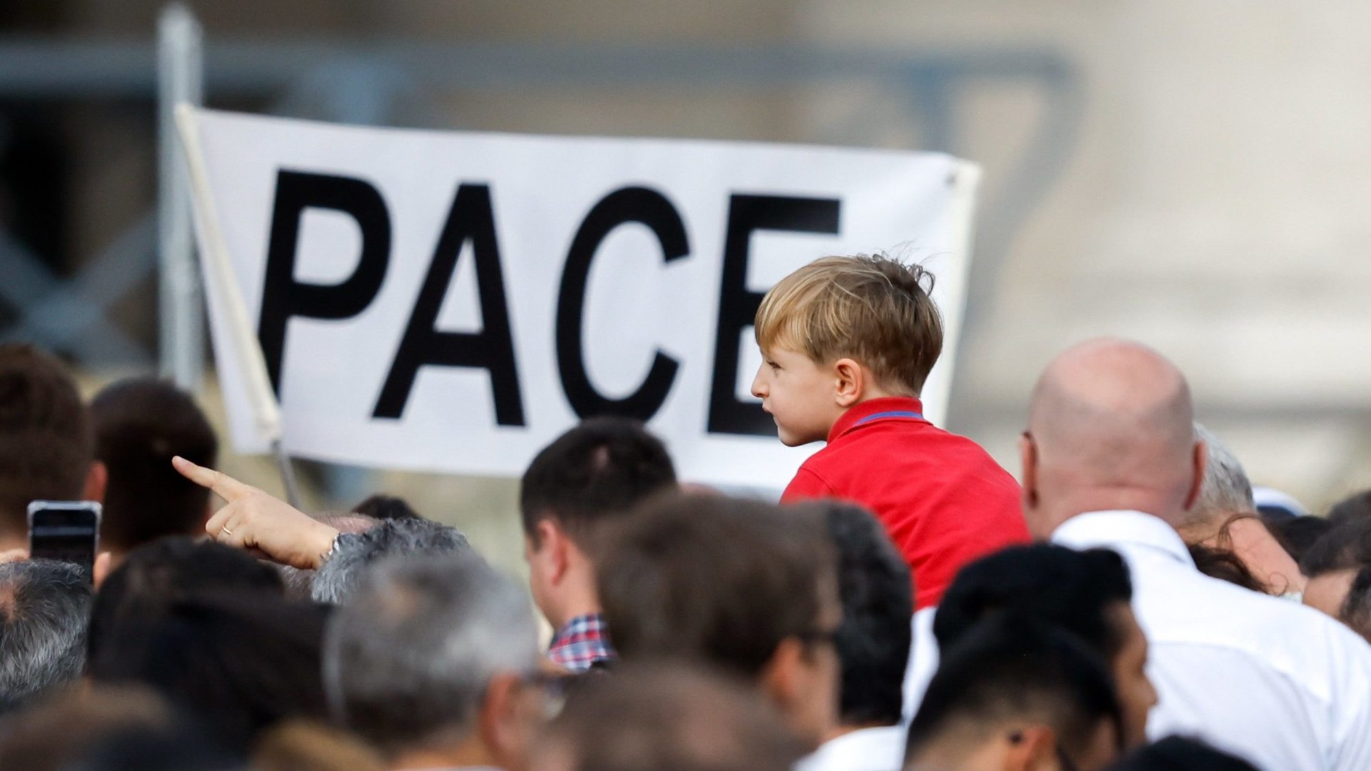 A child is near a sign that says "Pace," peace in Italian, as visitors gather to pray the Angelus with Pope Francis in St. Peter’s Square at the Vatican Oct. 29, 2023. (CNS/Lola Gomez)